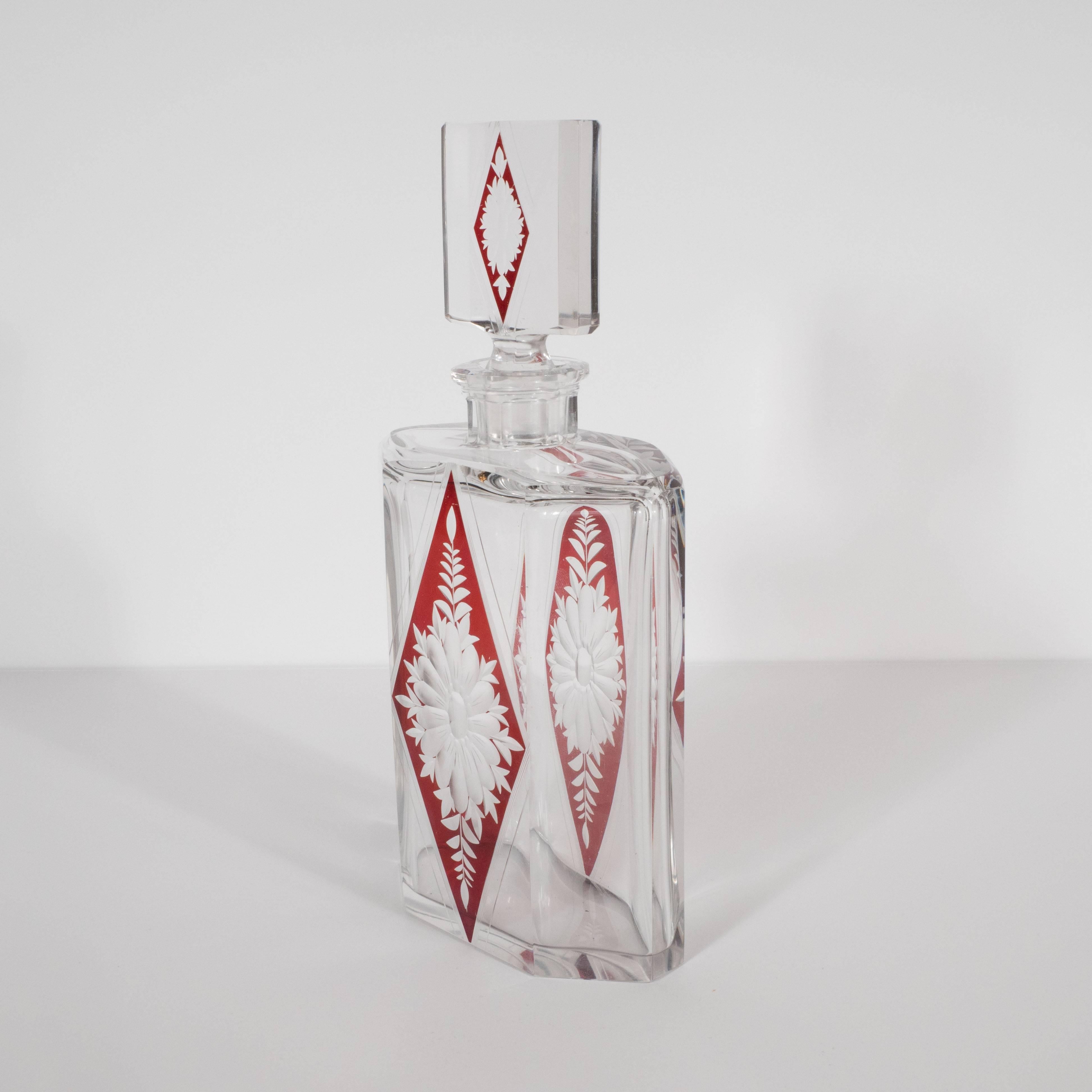 This stunning Art Deco decanter features an elongated hexagonal body in translucent glass with beveled sides. A triangular form in cardinal glass chased with a reeded border in clear glass adorns the central panel of the decanter (on both sides).