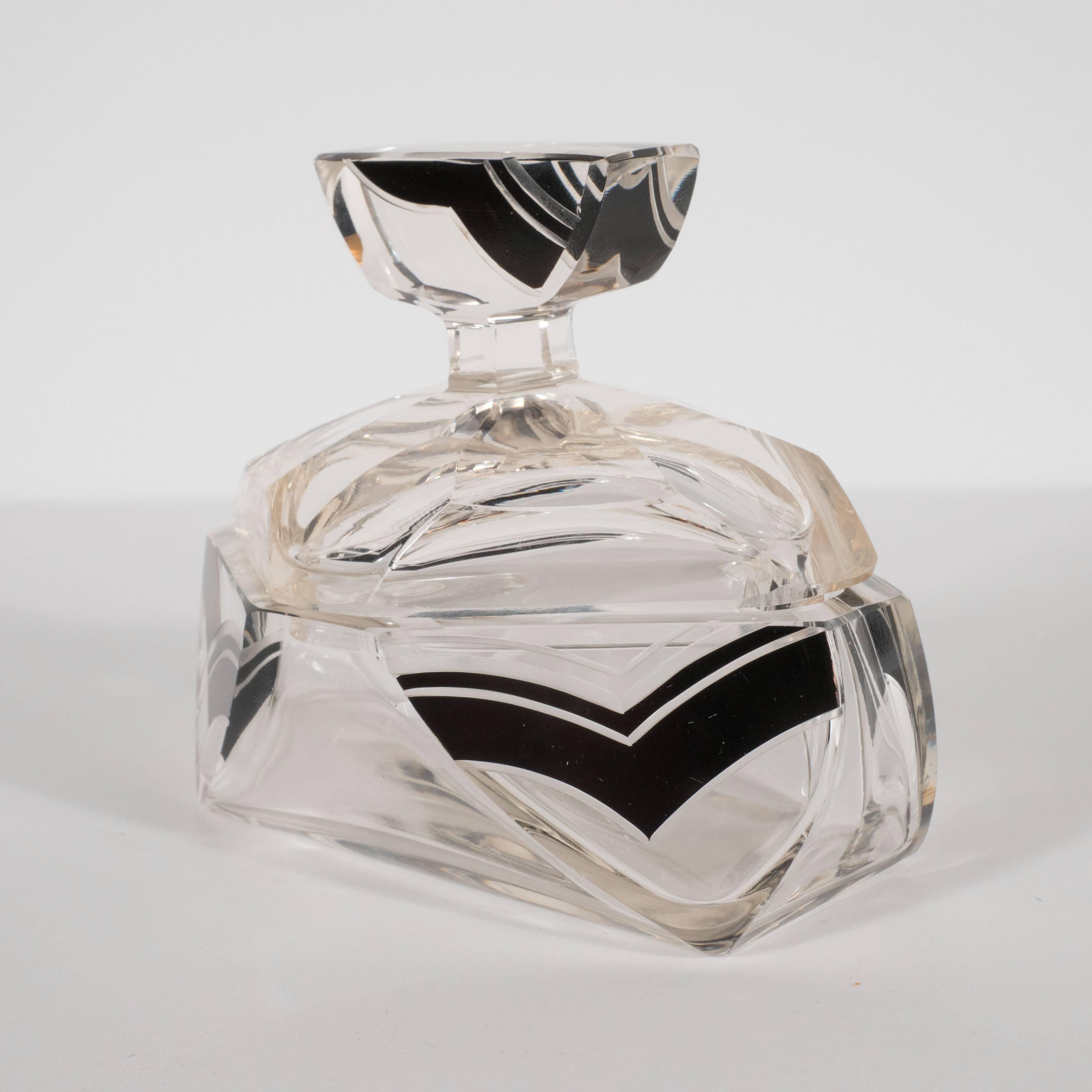 This elegant Art Deco glass perfume bottle was realized in the Czech Republic, circa 1930. It represents a particularly fine example of the renowned glass products of this time and place. It features an elongated octagonal with beveled sides as well