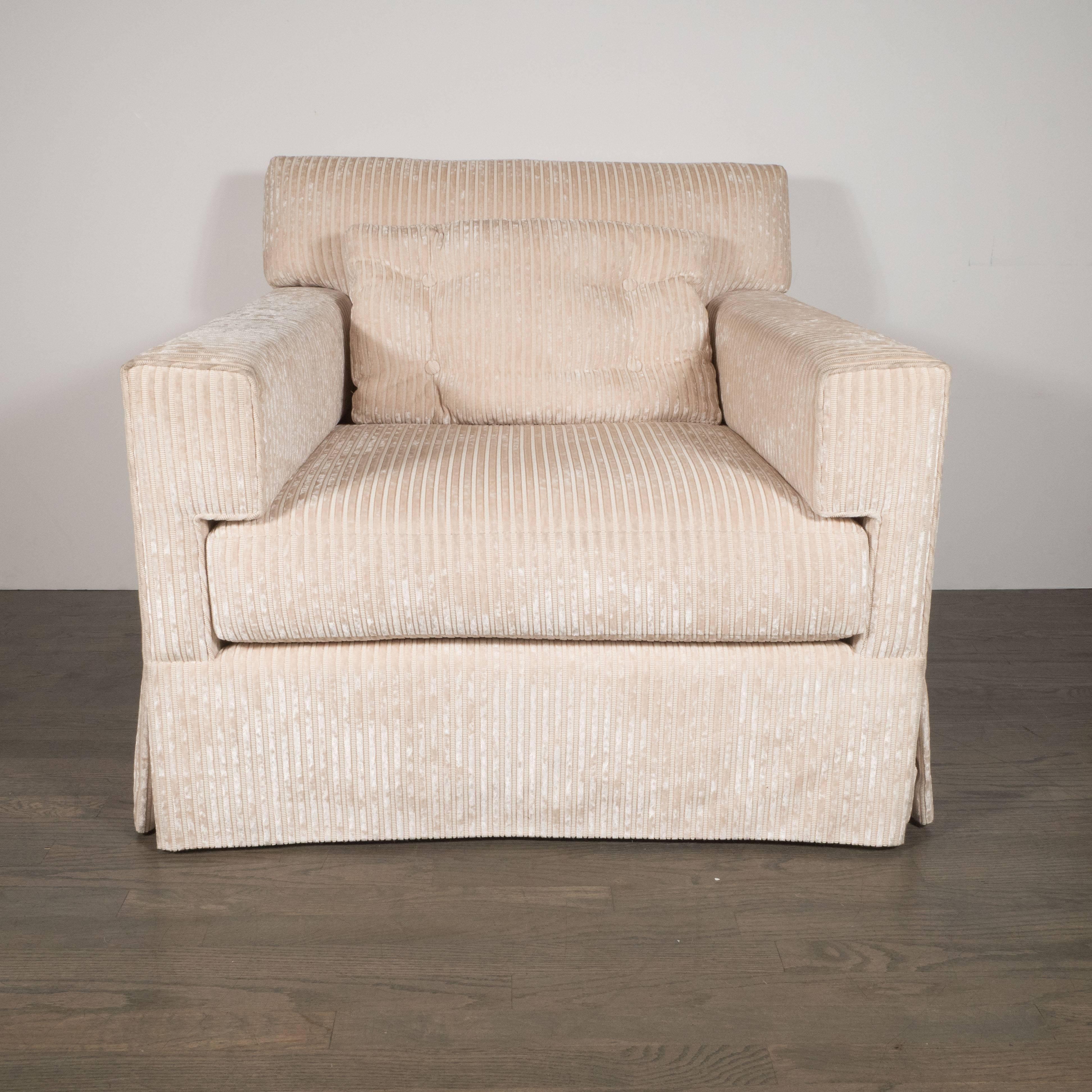 This modernist pair of swivel arm or club chairs has been upholstered in a luxe pearl corduroy fabric. With their bold lines and muscular form, these chairs would be a perfect complement to virtually any style of interior- not to mention they are