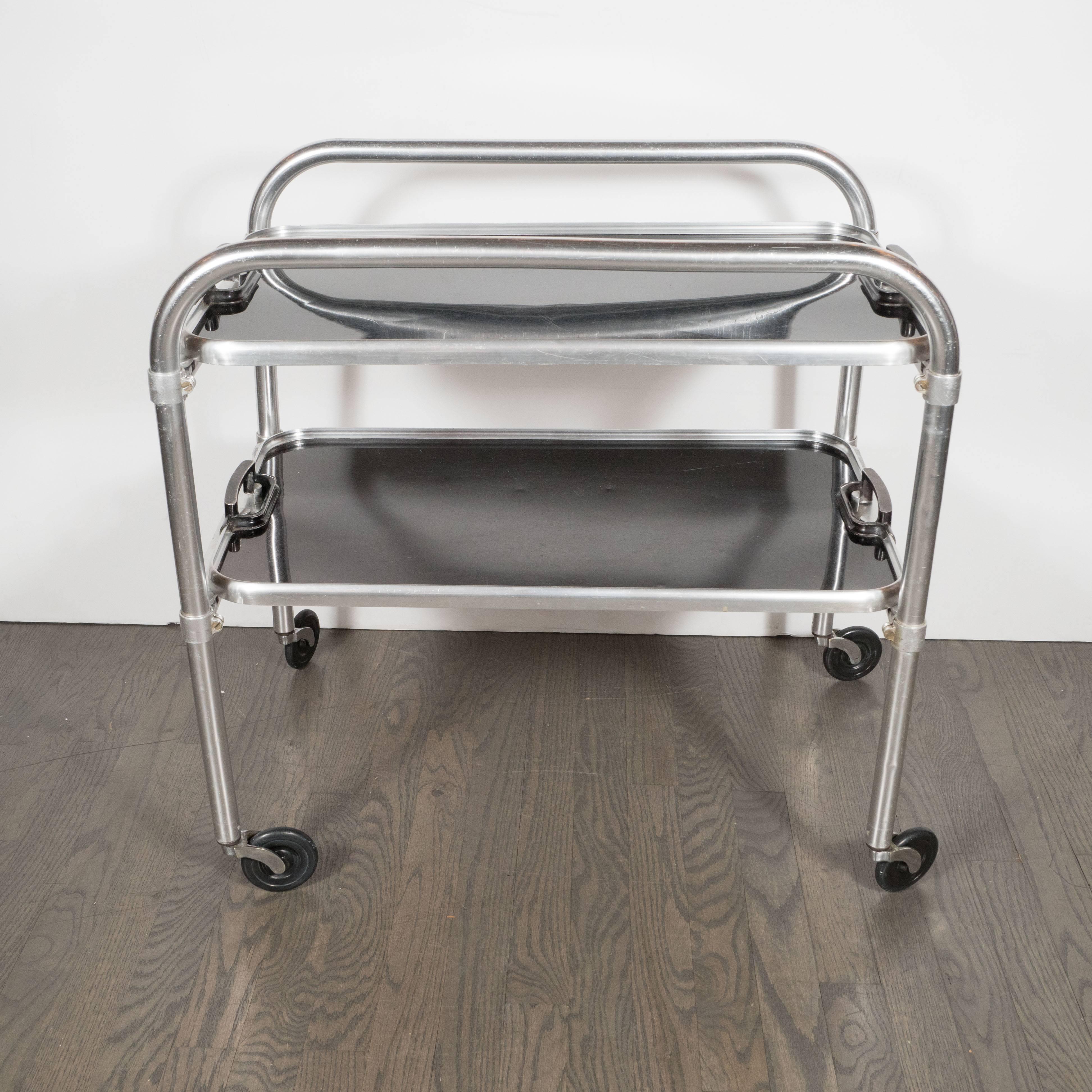 This sophisticated bar cart offers the austere lines and Industrial materials, repurposed into compelling design, that collectors of the period prize. It represents an Art Deco object, that clearly reflects the influence of Bauhaus design. It