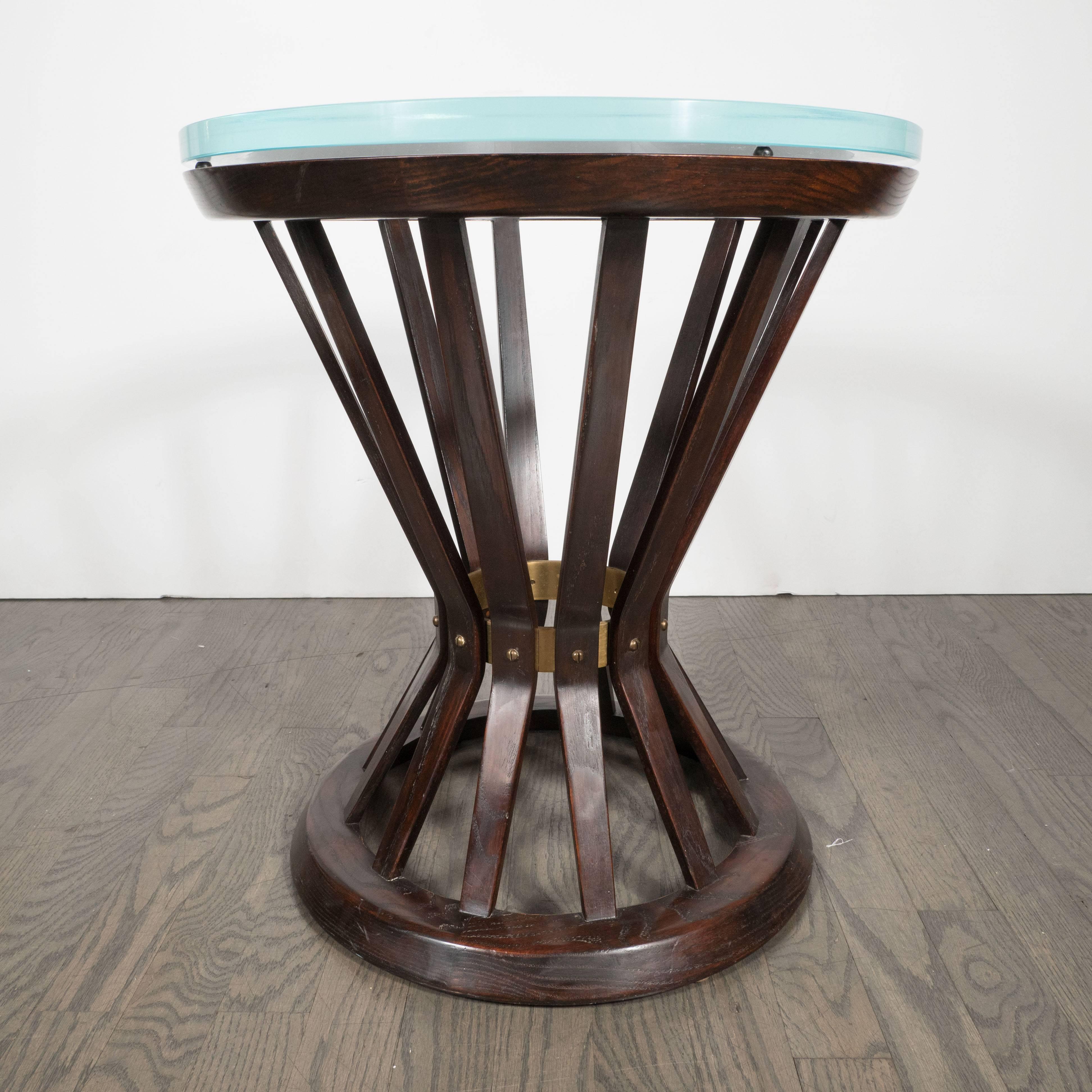 This sophisticated Mid-Century Modern occasional table was created by the illustrious American designer Edward Wormley for Dunbar. It features a geometric hourglass form with multiple stokes of ebonized walnut tapering towards the center where they