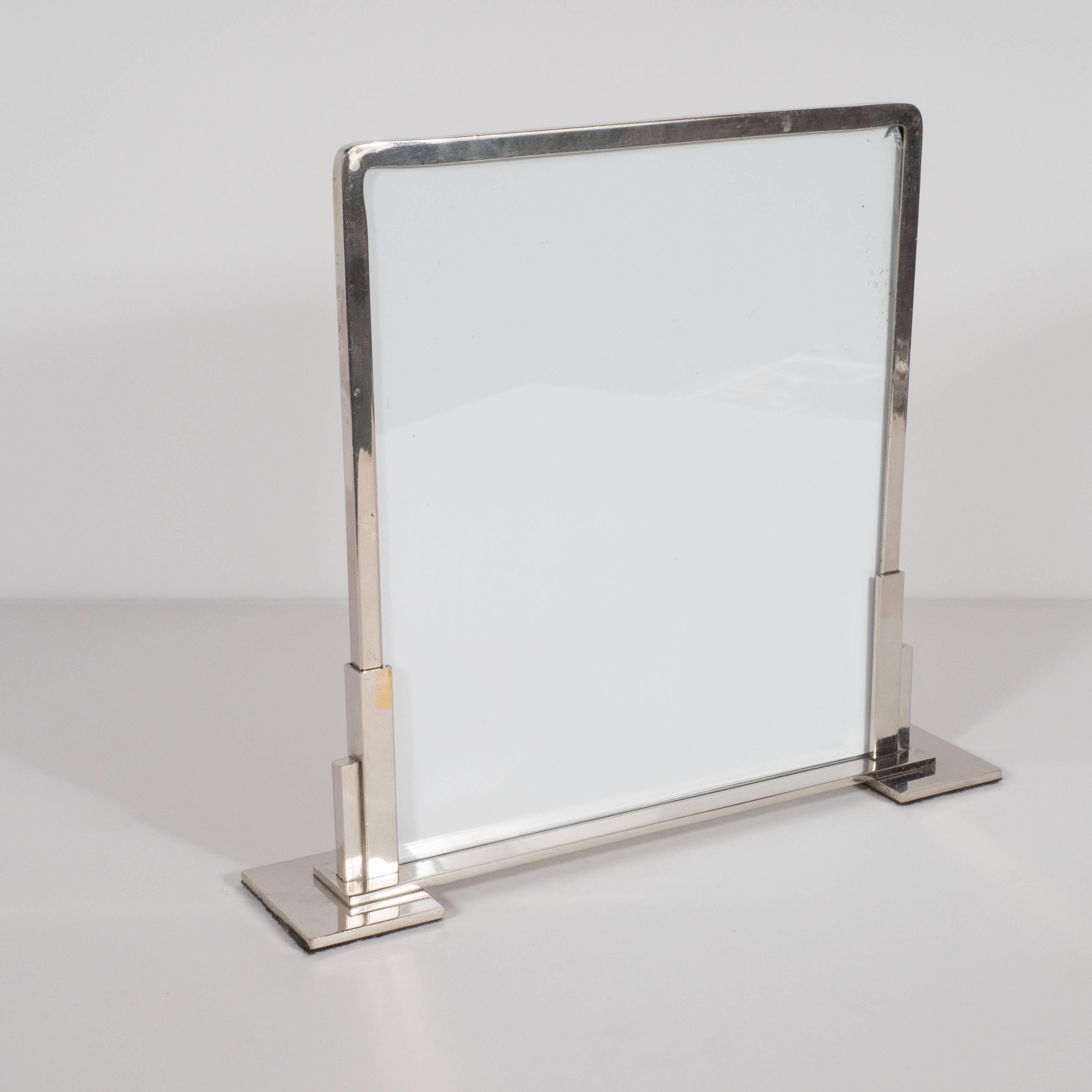 This refined chrome Machine Age picture frame was realized in France, circa 1930, at the height of Art Deco. It is a fine example of the period, with a skyscraper style base supported by flat square feet. It would make a winning acquisition for any
