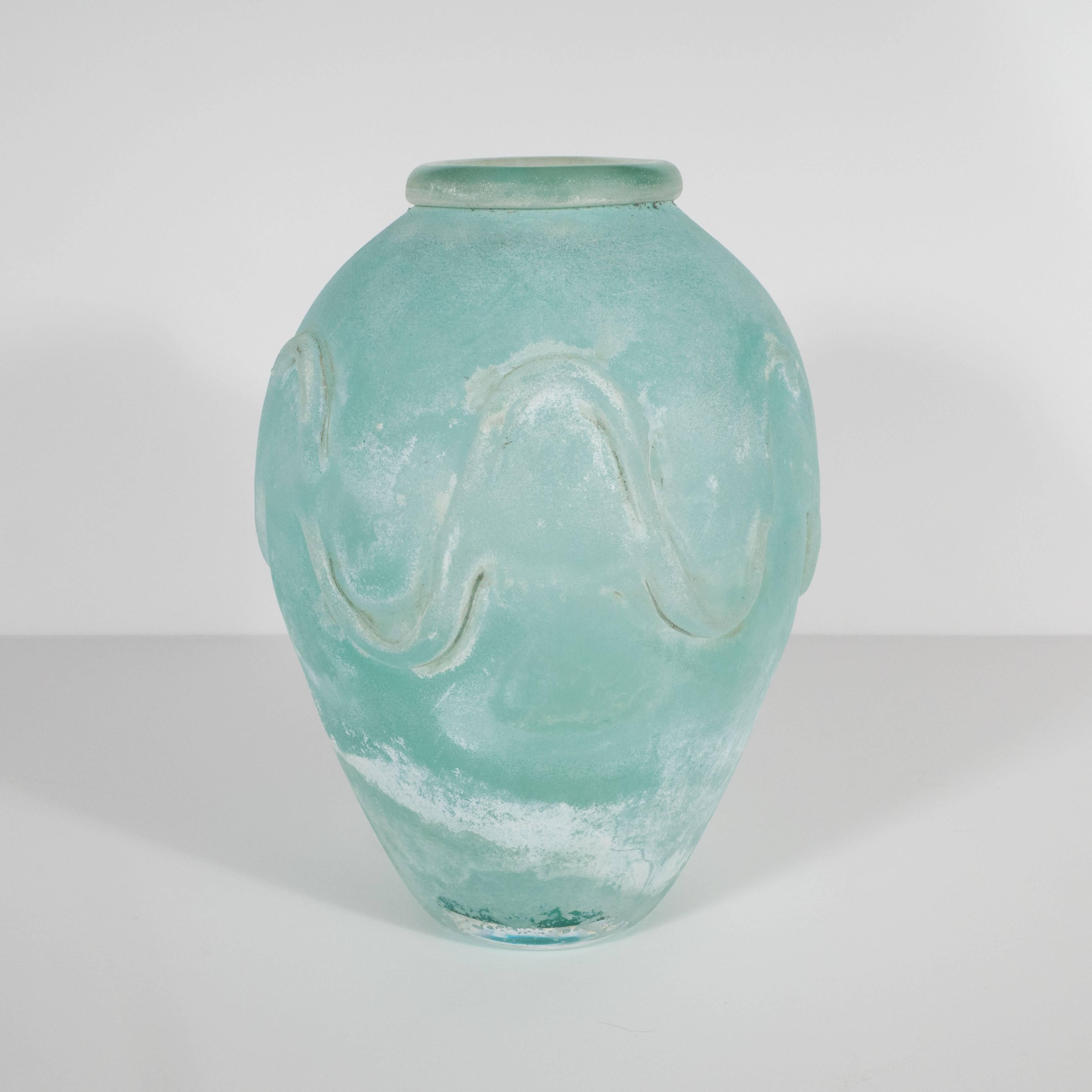This stunning handblown vase was handblown on the Venetian island of Murano by Seguso- one of Italy's most illustrious producers. It is inscribed on the side with a wave pattern that mirrors the sinuous curves of the form itself. The Scavo finished