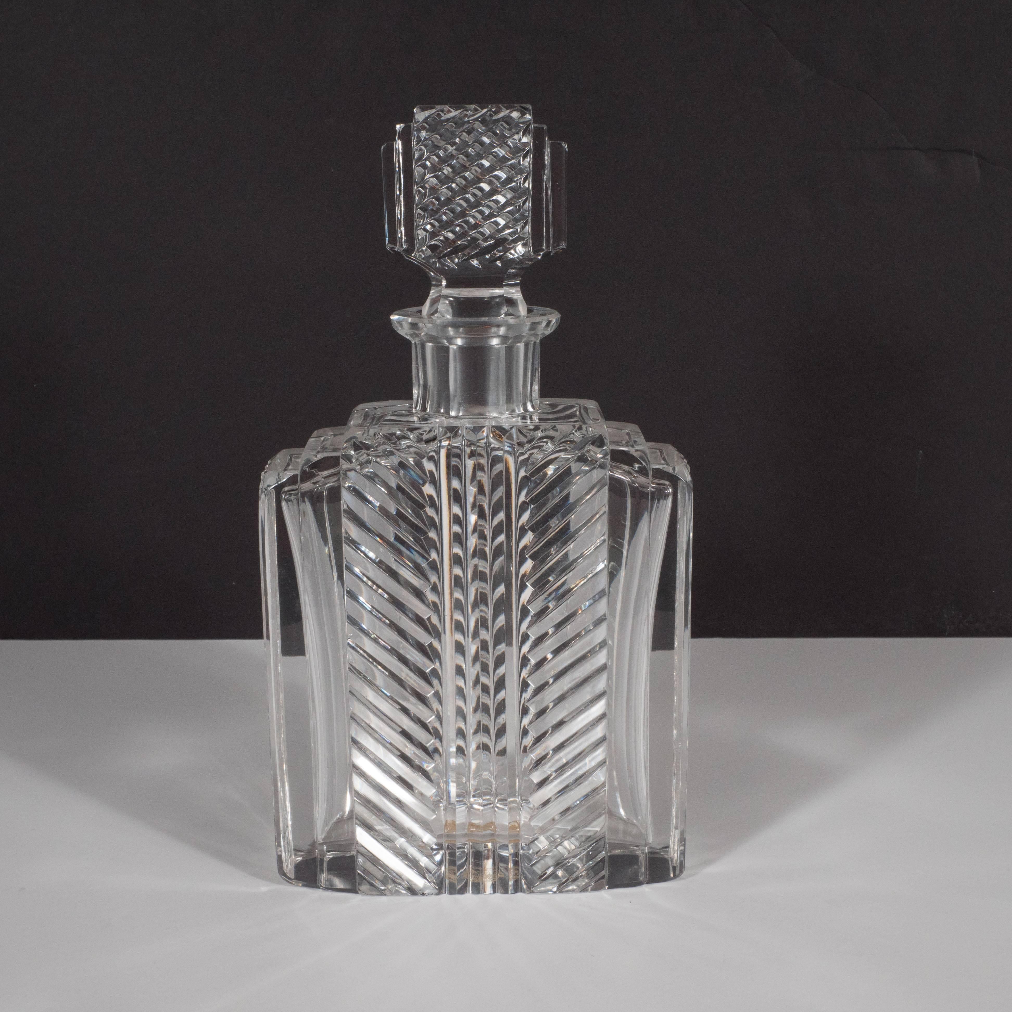 This exquisite Art Deco crystal decanter was realized in Salzburg, Austria by the illustrious maker Rasper & Sohne, circa 1930. It features three tiers stepped and bevelled glass that meets a pyramidally reeded channel in the centre. Two rows of