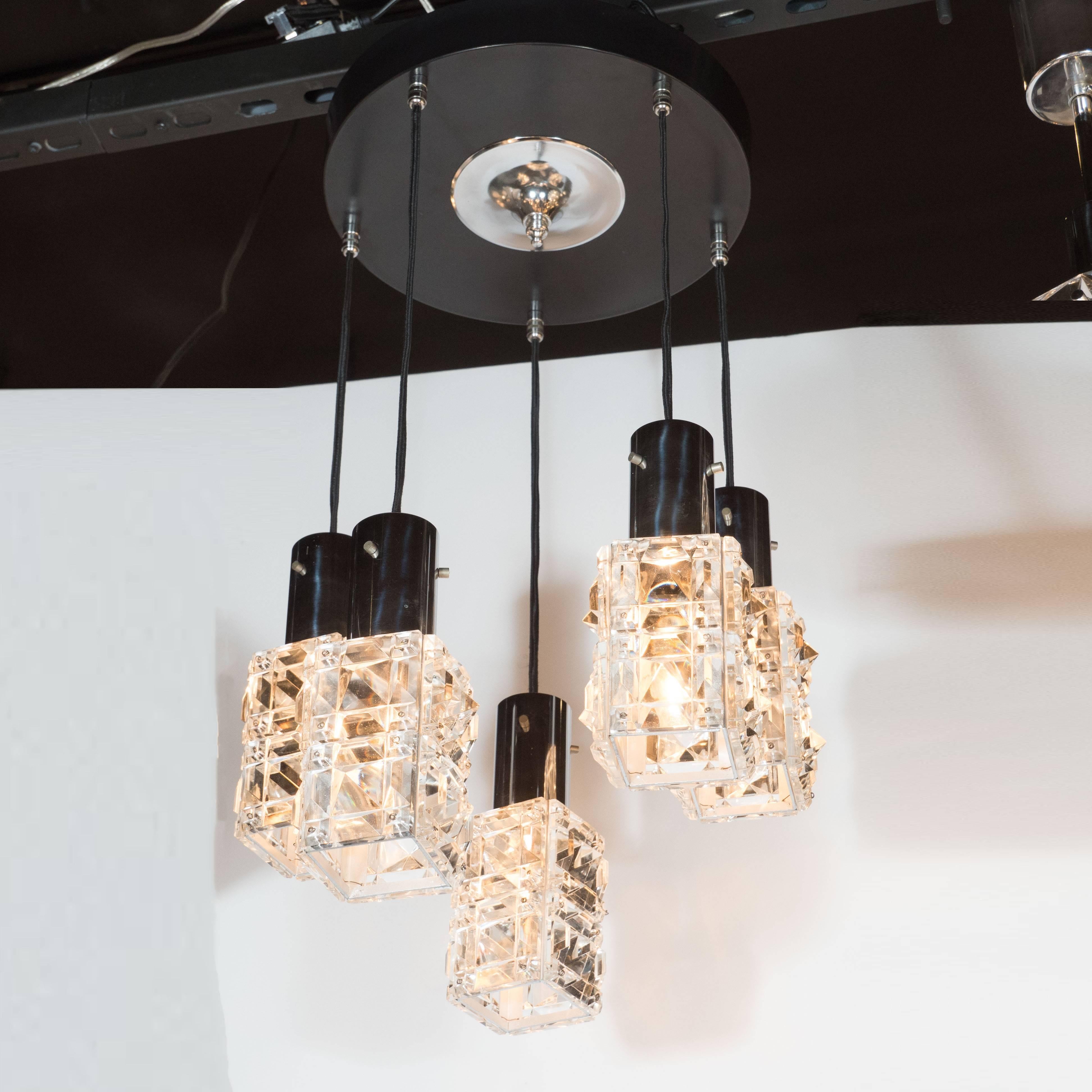 This quintessentially Mid-Century Modern fixture was realized by the esteemed producer J.T. Kalmar- one of the most illustrious names in European 20th century lighting, circa 1960. It features five translucent cut crystal shades etched with raised