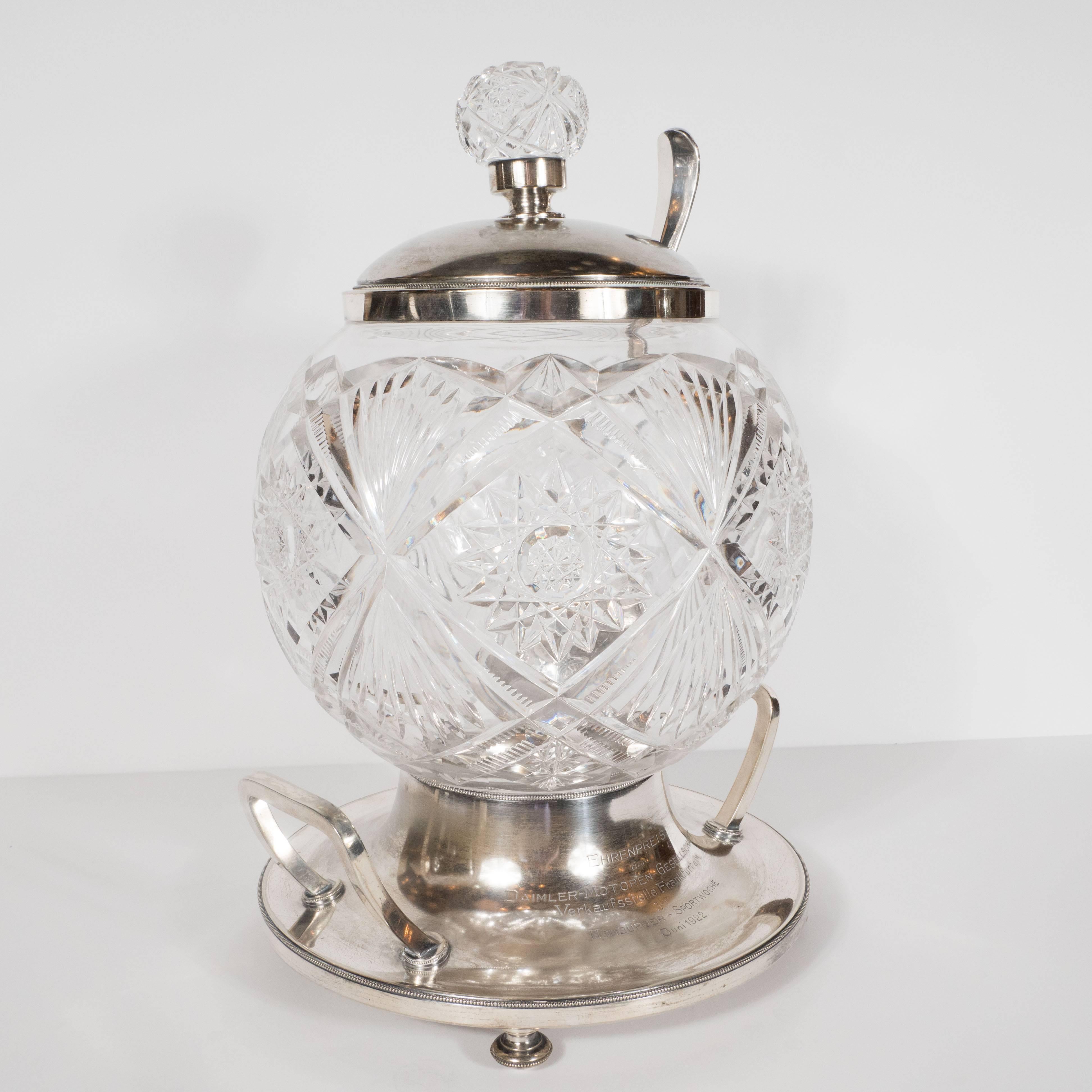 This exquisite punch bowl was realized in cut crystal and silver plate for the Daimler Motor Company in June of 1922. It embodies the superlative craftsmanship rarely seen today in its elaborate starburst and geometric patterns etched throughout and