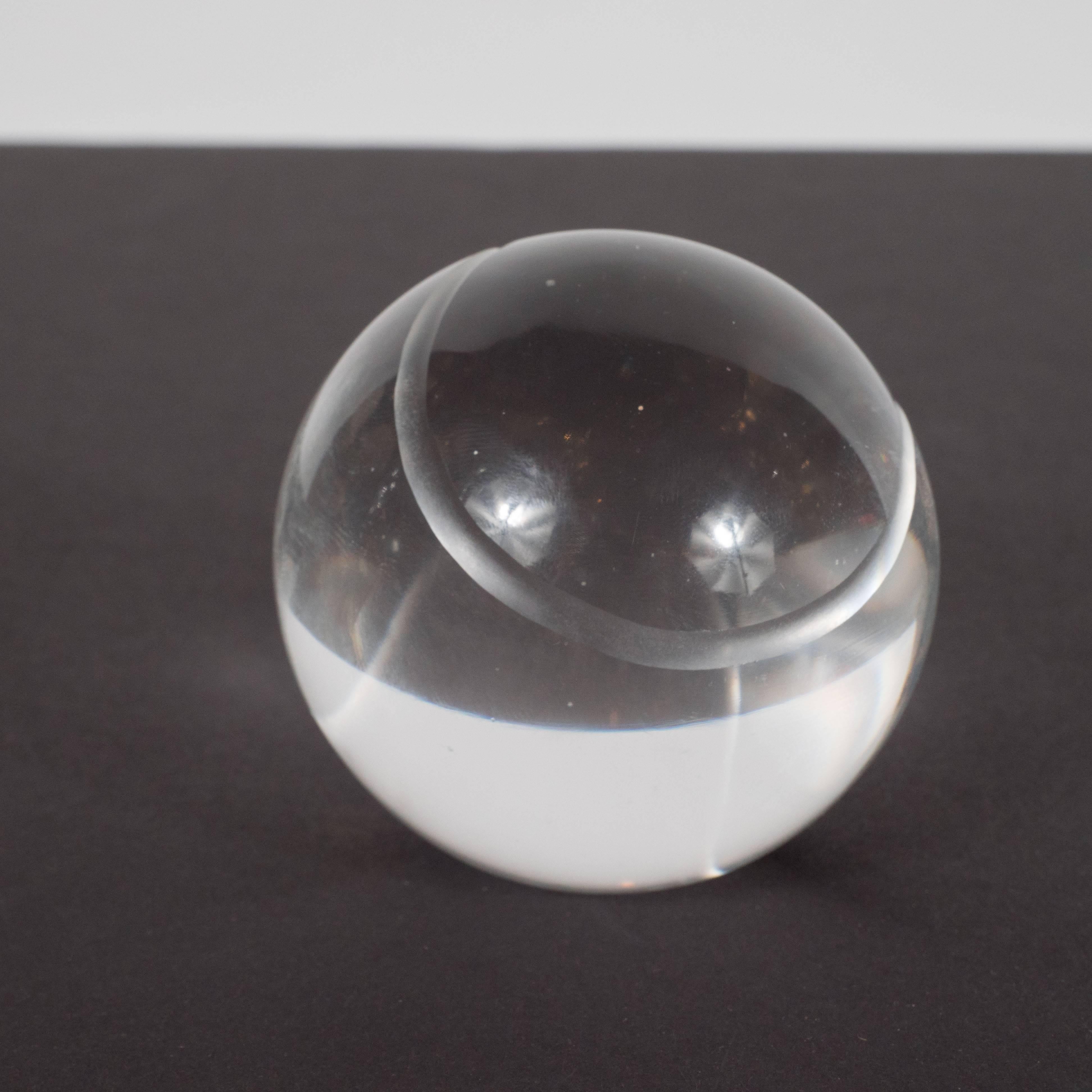 This refined Mid-Century Modern baseball paperweight- executed in translucent crystal- represents the simple elegance of Tiffany & Co. at its finest. Since its founding in 1837, Tiffany has produced among the highest quality luxury items- especially