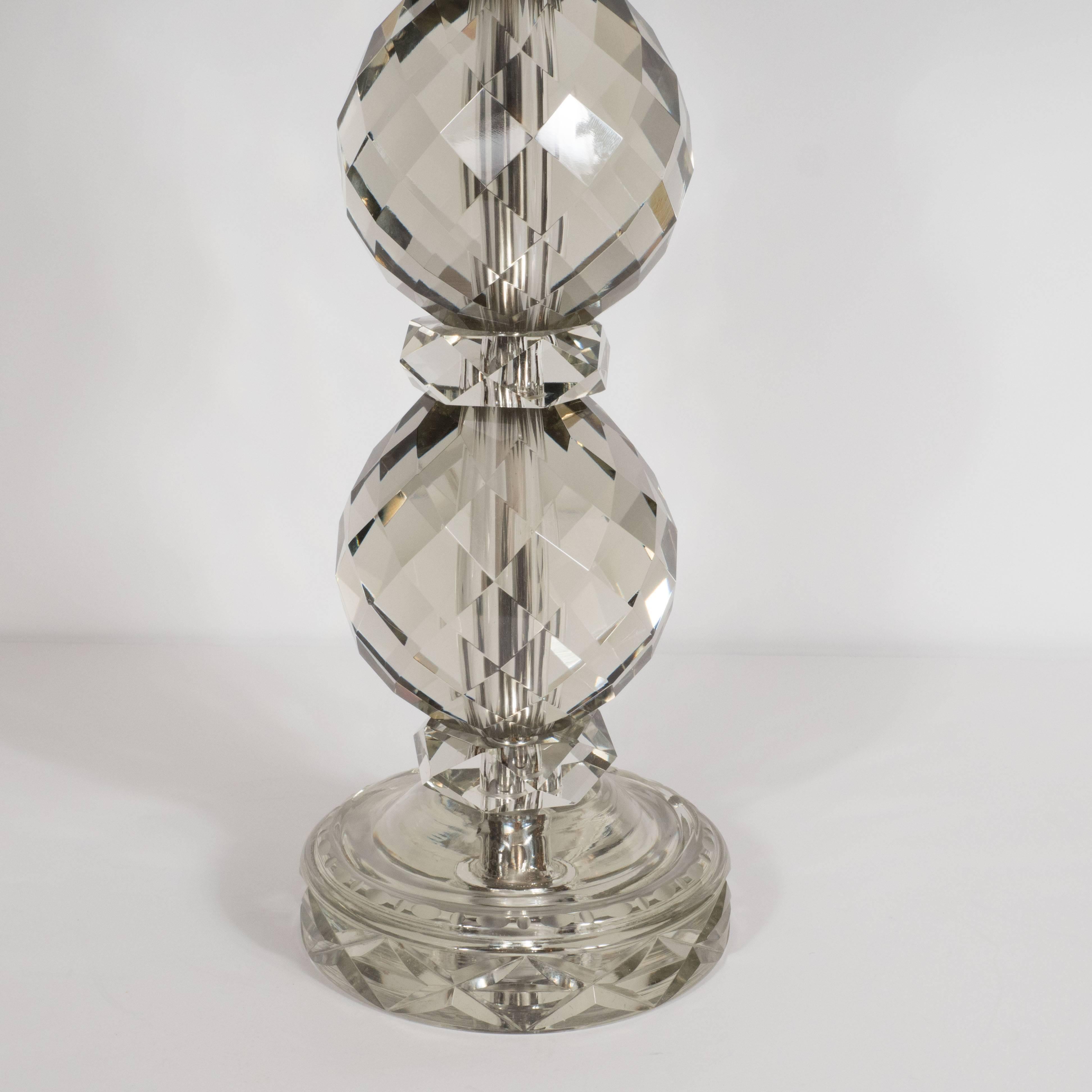 This elegant pair of table lamps features features four crystal globes with beveled sides around a central rod with circular beveled spacers between them. Each of the smoked crystal forms feature diamond shape hand beveled forms, evident in the fact