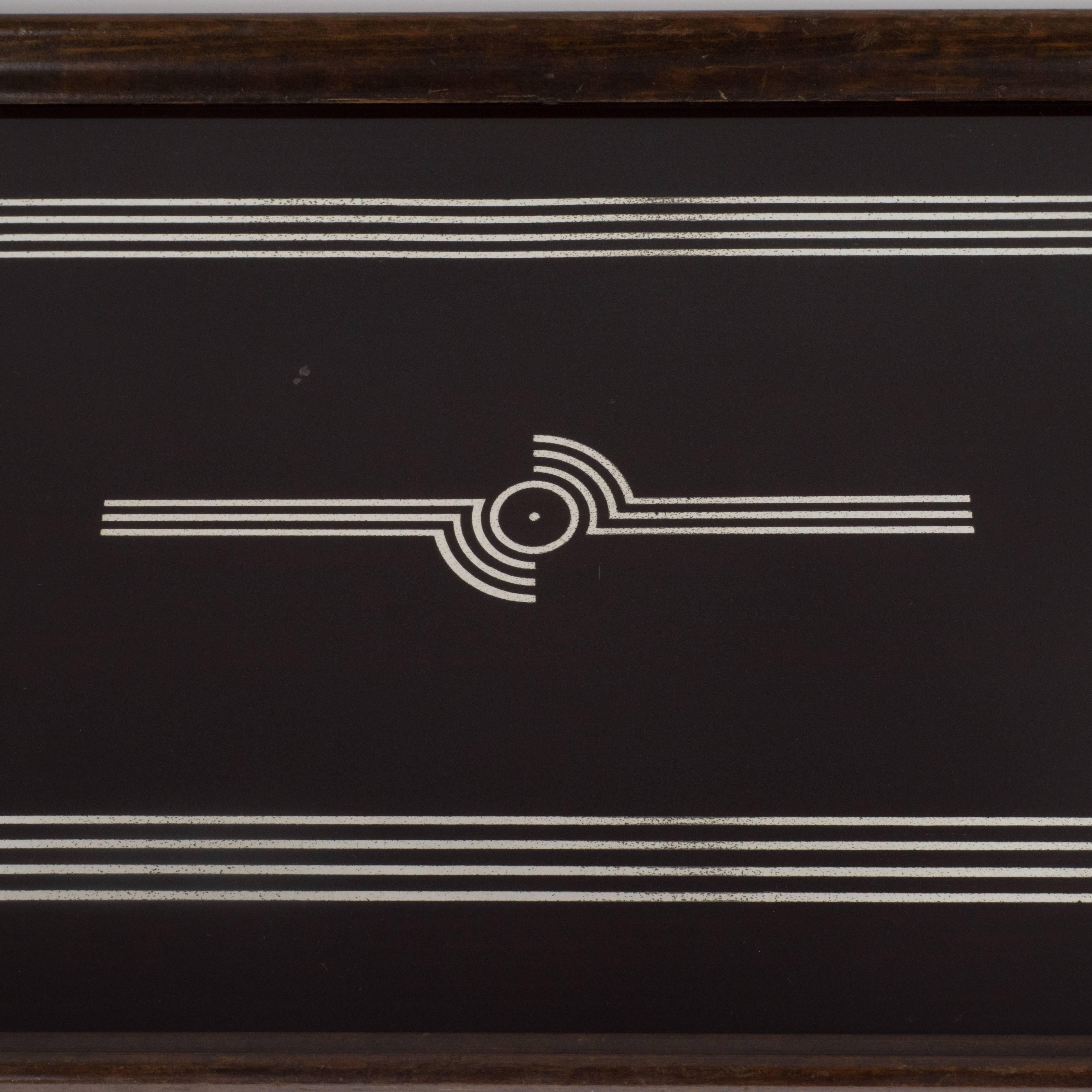 This elegant tray features glass hand-painted geometric streamlined designs in sterling silver over an ebonized walnut body. The perimeter body has been executed in hand rubbed walnut with pentagonal handles of the same material. This is a beautiful