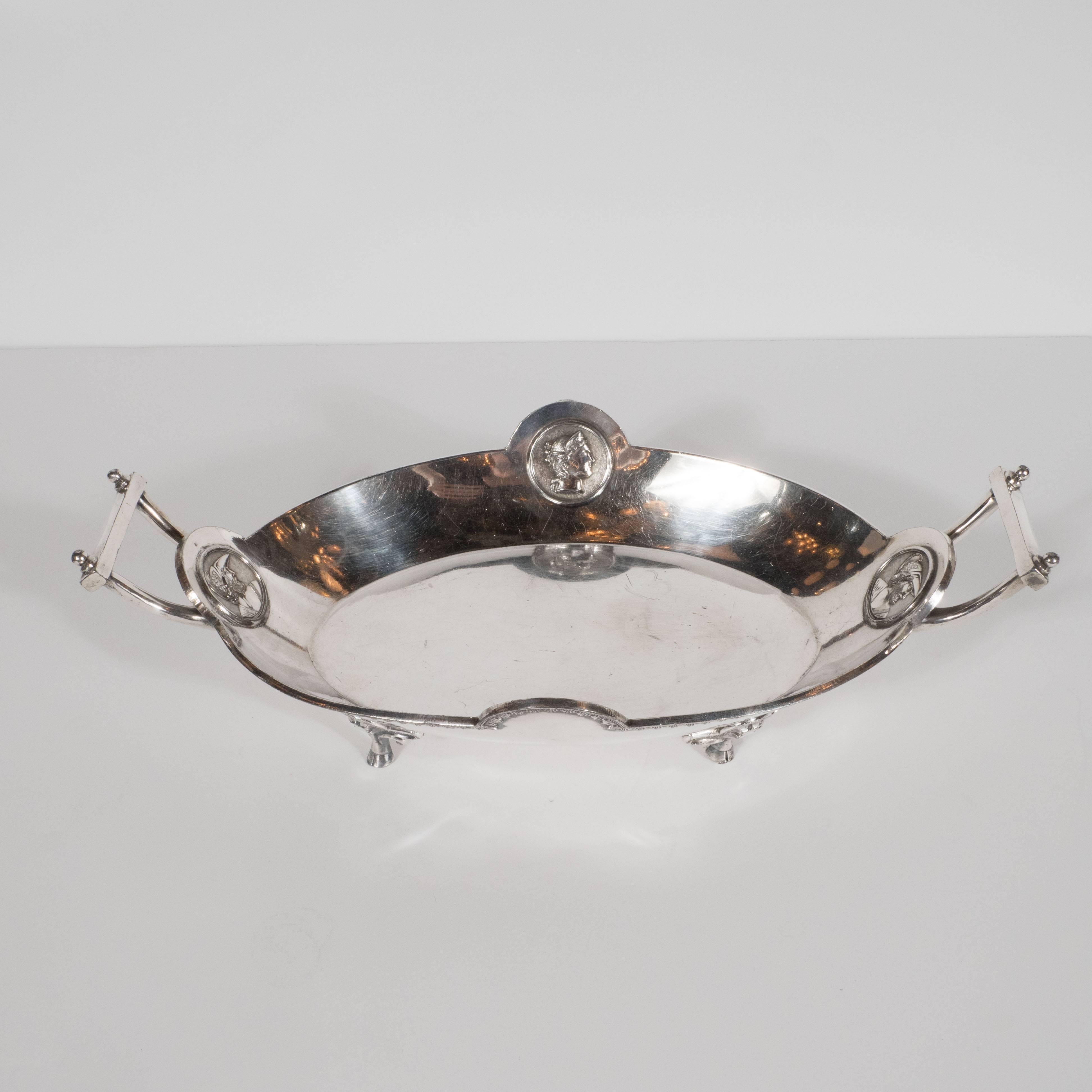 This refined antique handled bowl was produced by Redfield & Rice- an esteemed producer of silver wares based in New York State. The bowl has a flat ovoid centre and steeply sloped sides. The two curved handles are connected via a flat rectangular