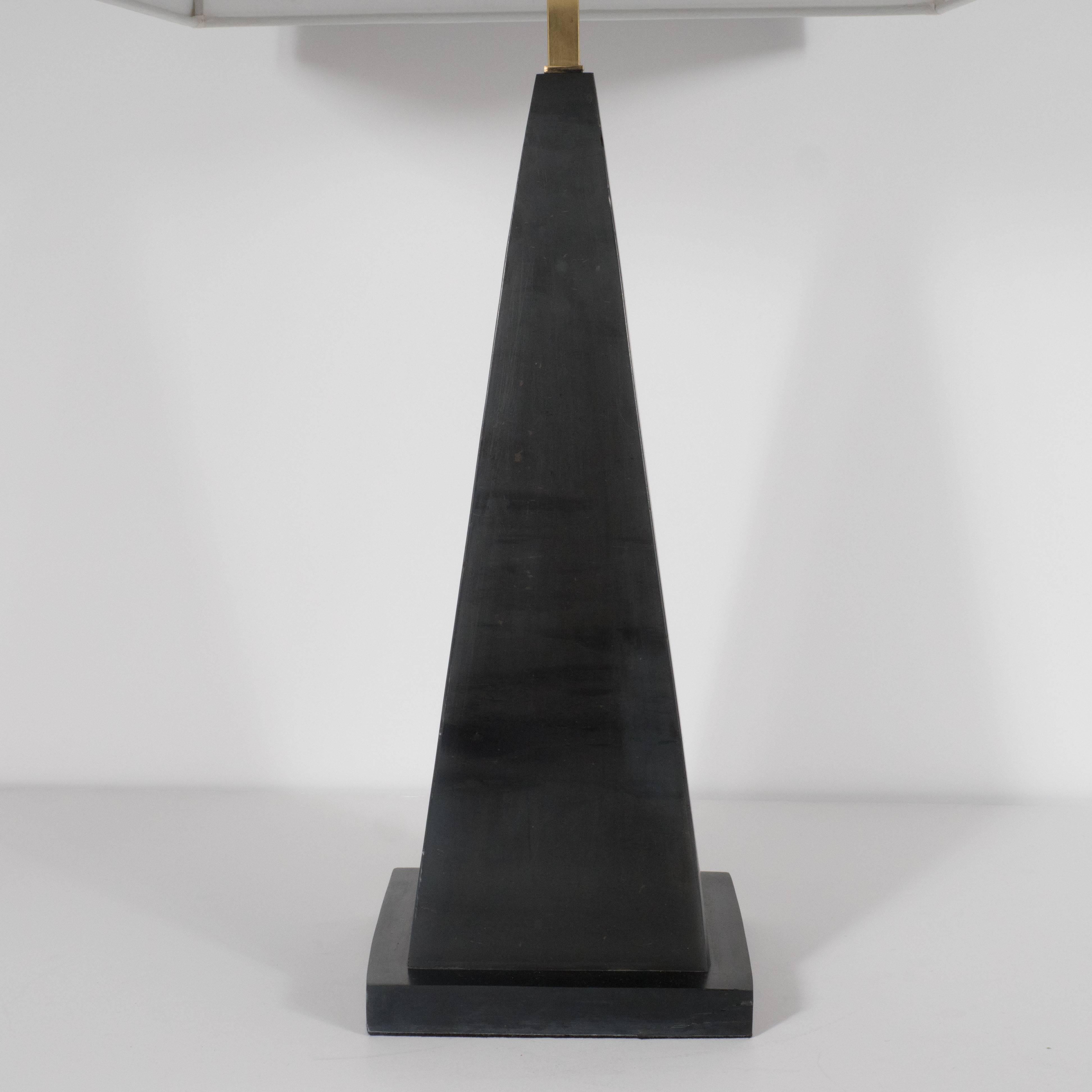 This sophisticated pair of table lamps were realized in America, circa 1980. They feature pyramidal plinth forms rising from square bases. They have been executed in metal finished in a dark slate gray glaze. With their austere silhouettes and luxe