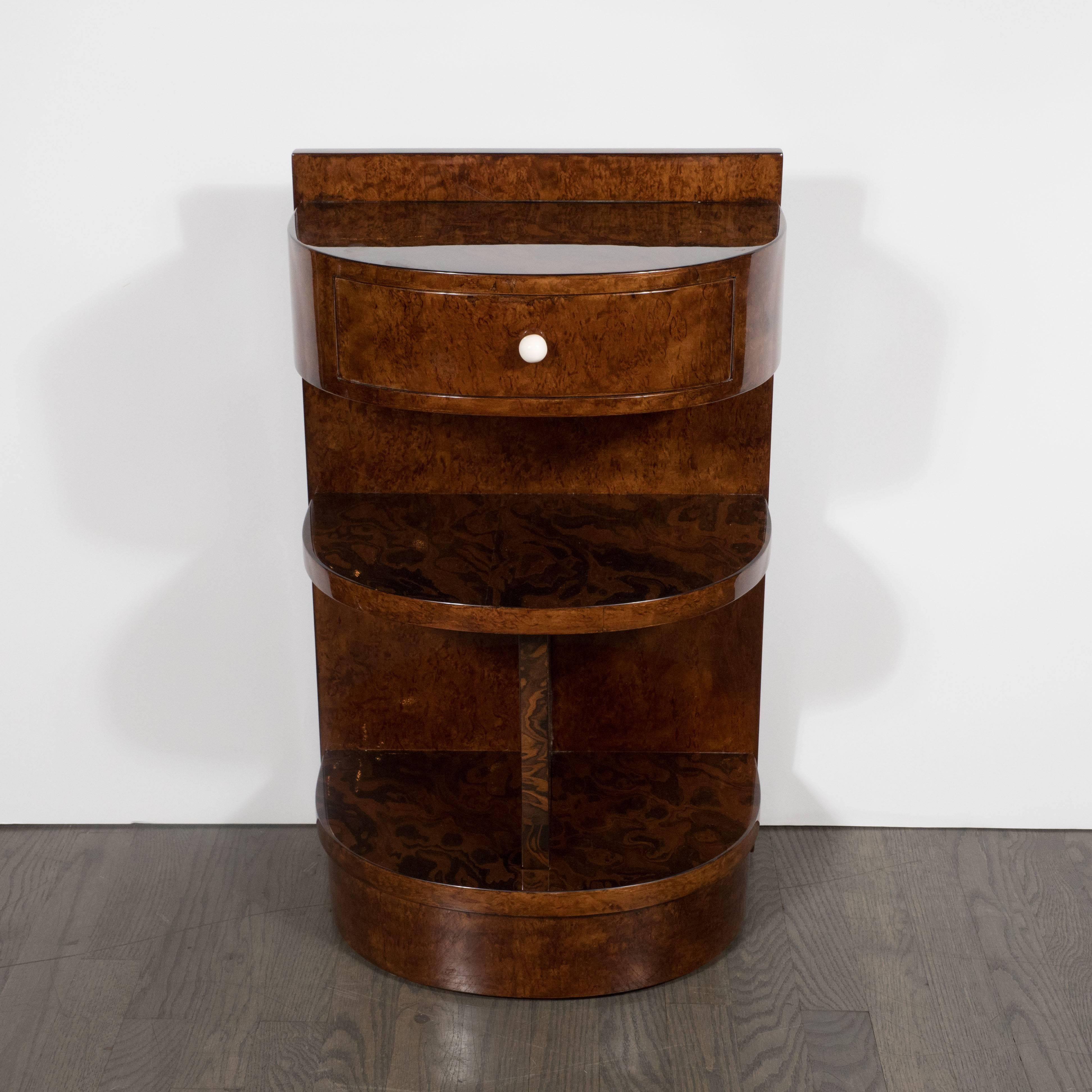 This pair of Demilune nightstands were realized from burled exotic wood and book-matched Carpathian Elm in France, circa 1930 at the height of Art Deco. They represent Fine examples of the time and place. They feature three shelves and a drawer,