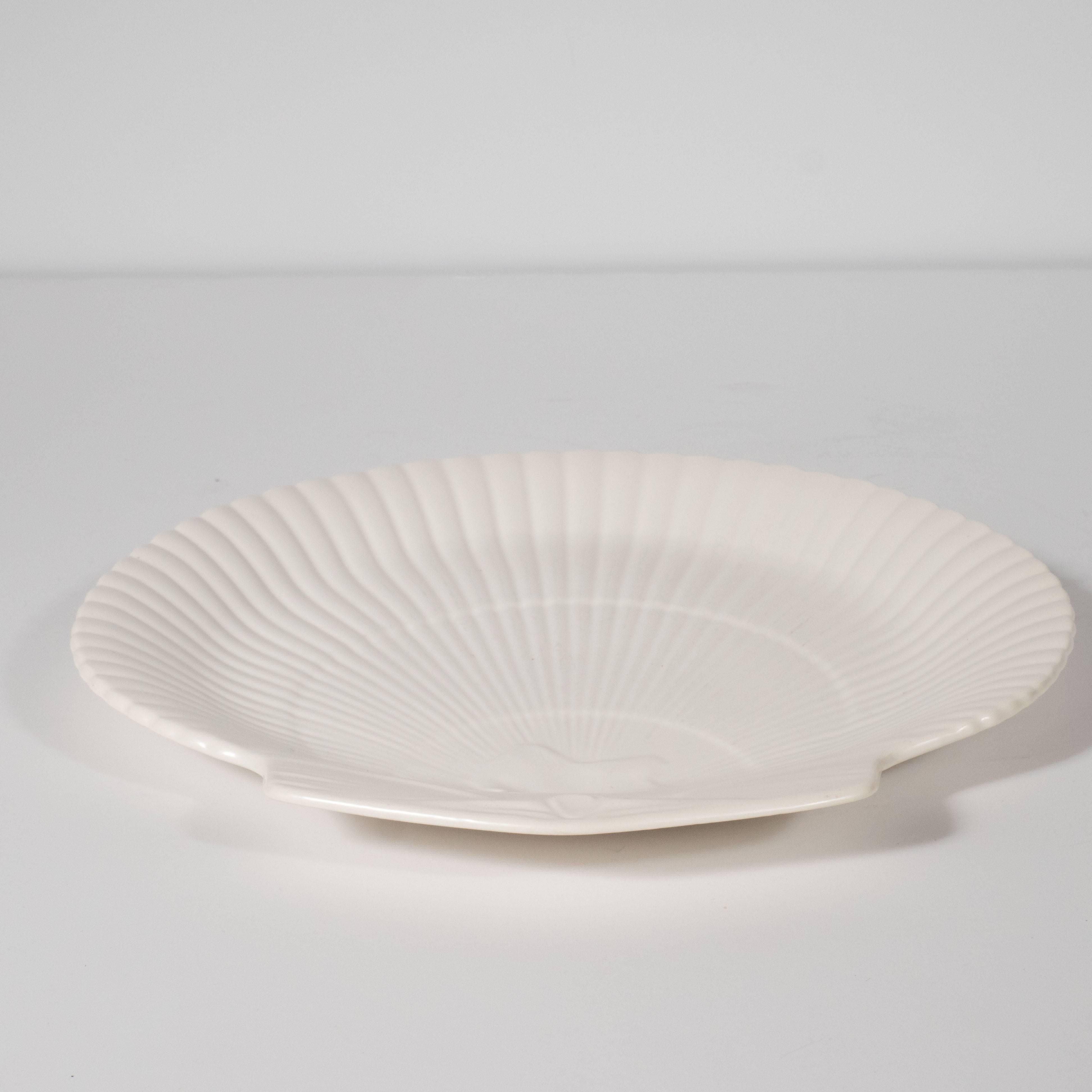 This elegant set of twelve scallop dishes were realized by Wedgwood- one of the most renowned pottery makers in England, circa 1950. Each offers the form of a scallop shell with an abundance of ray-like striations emanating from the bottom centre