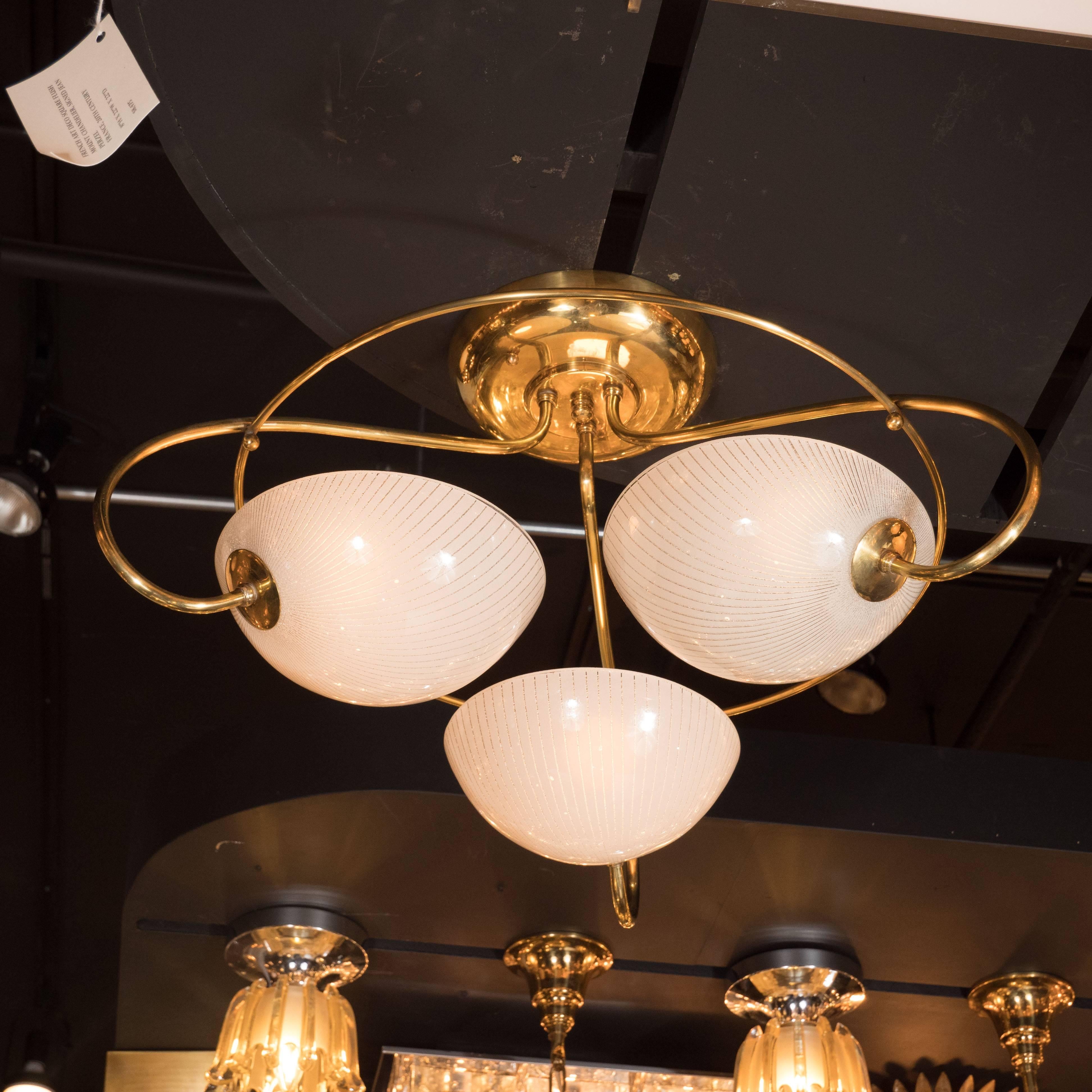 This gorgeous flush mount chandelier created in the United States, circa 1960. Its sinuous curves, and luxurious materials make it an exceptional example of the time and place. Three curving arms descend from a circular canopy, encircled by a
