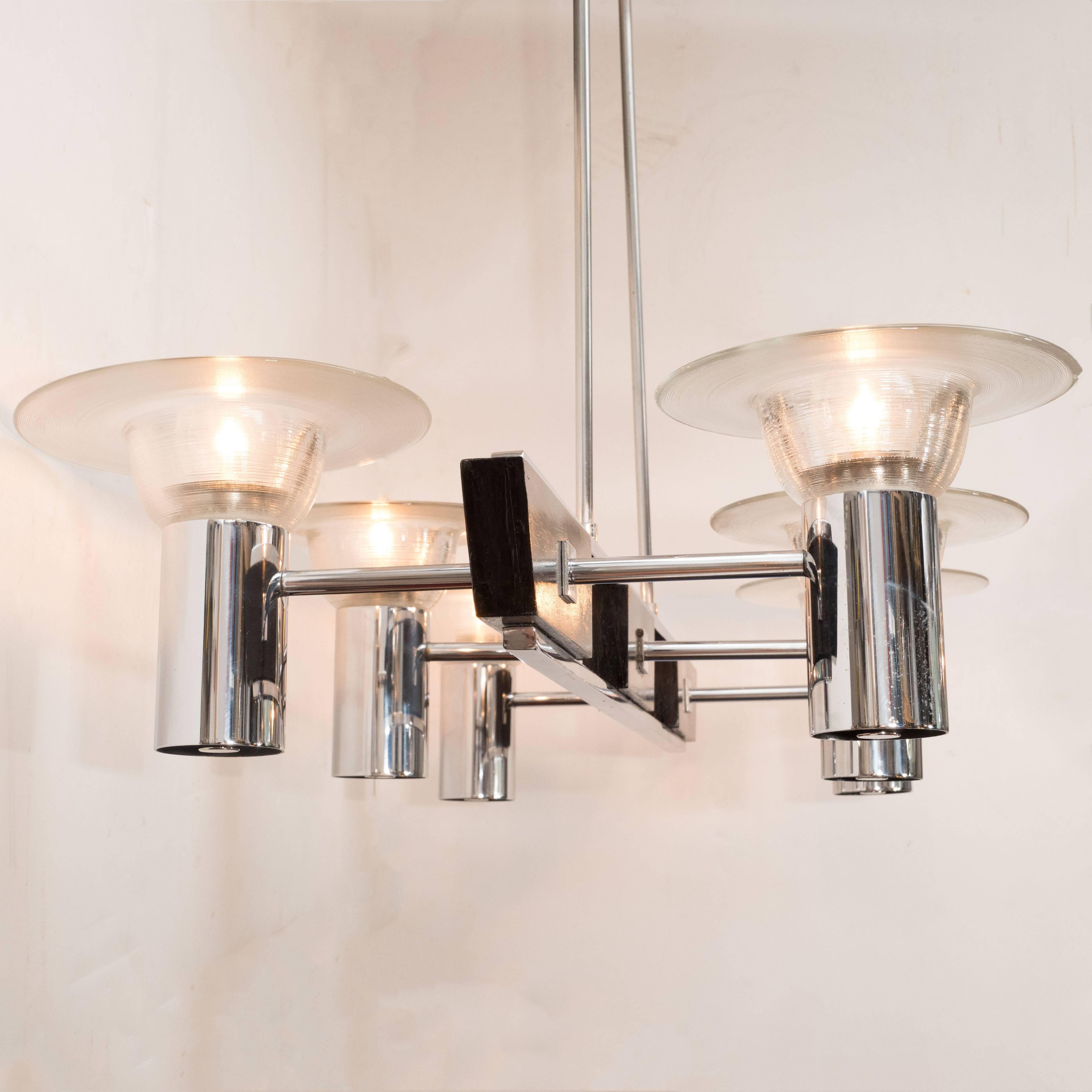 This sophisticated Mid-Century Modern six-arm chandelier was realized in Germany, circa 1960. With its clean lines and superlative construction, it represents an exceptionally fine example of the time and place. The fixture hangs, via two chrome