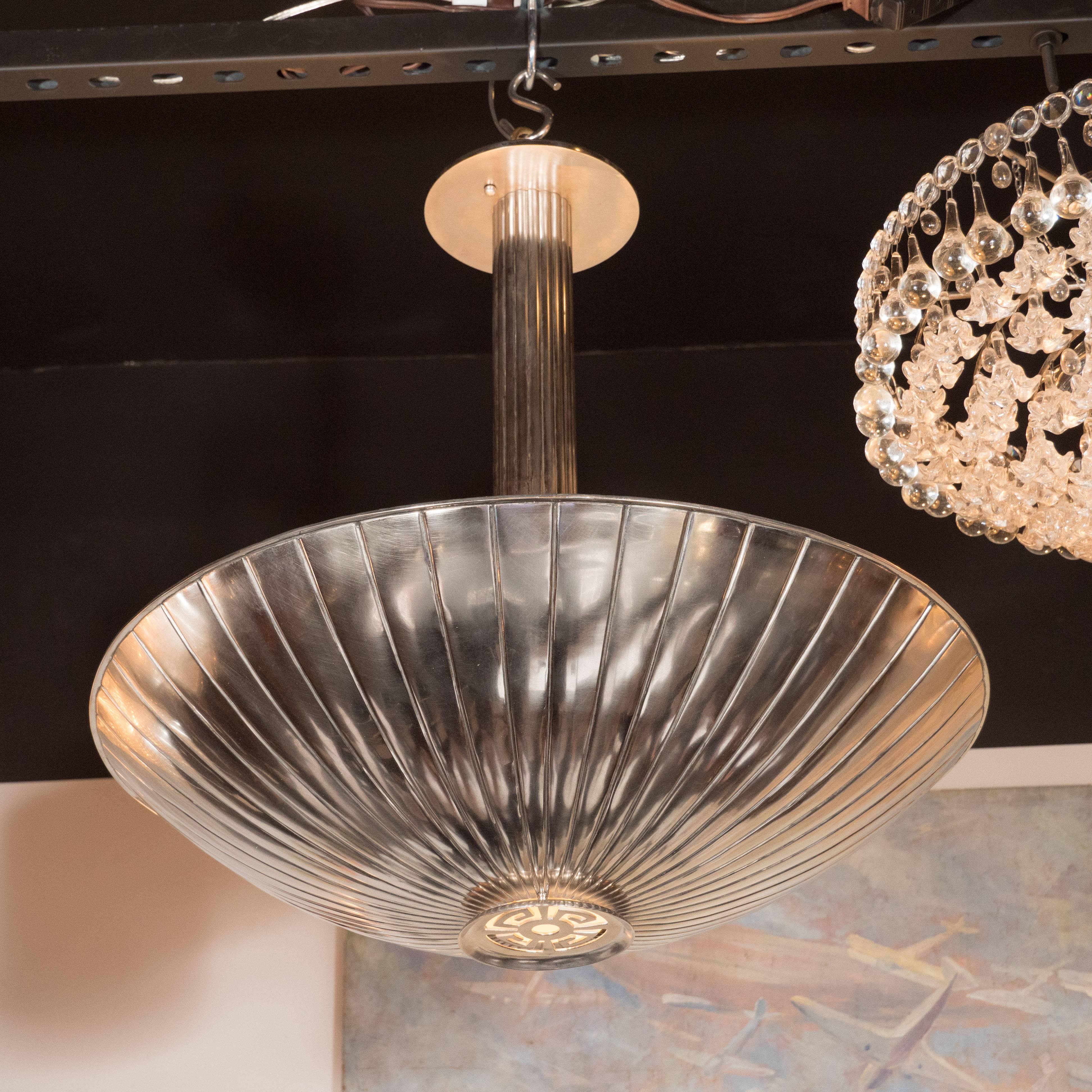 This American Art Deco combines the best of Machine Age and classical design. It features a domed nickel shade with a circular inset suggesting deconstructed Greek keys. Striated rays, chased into the nickel, outwards from this central cutout, like