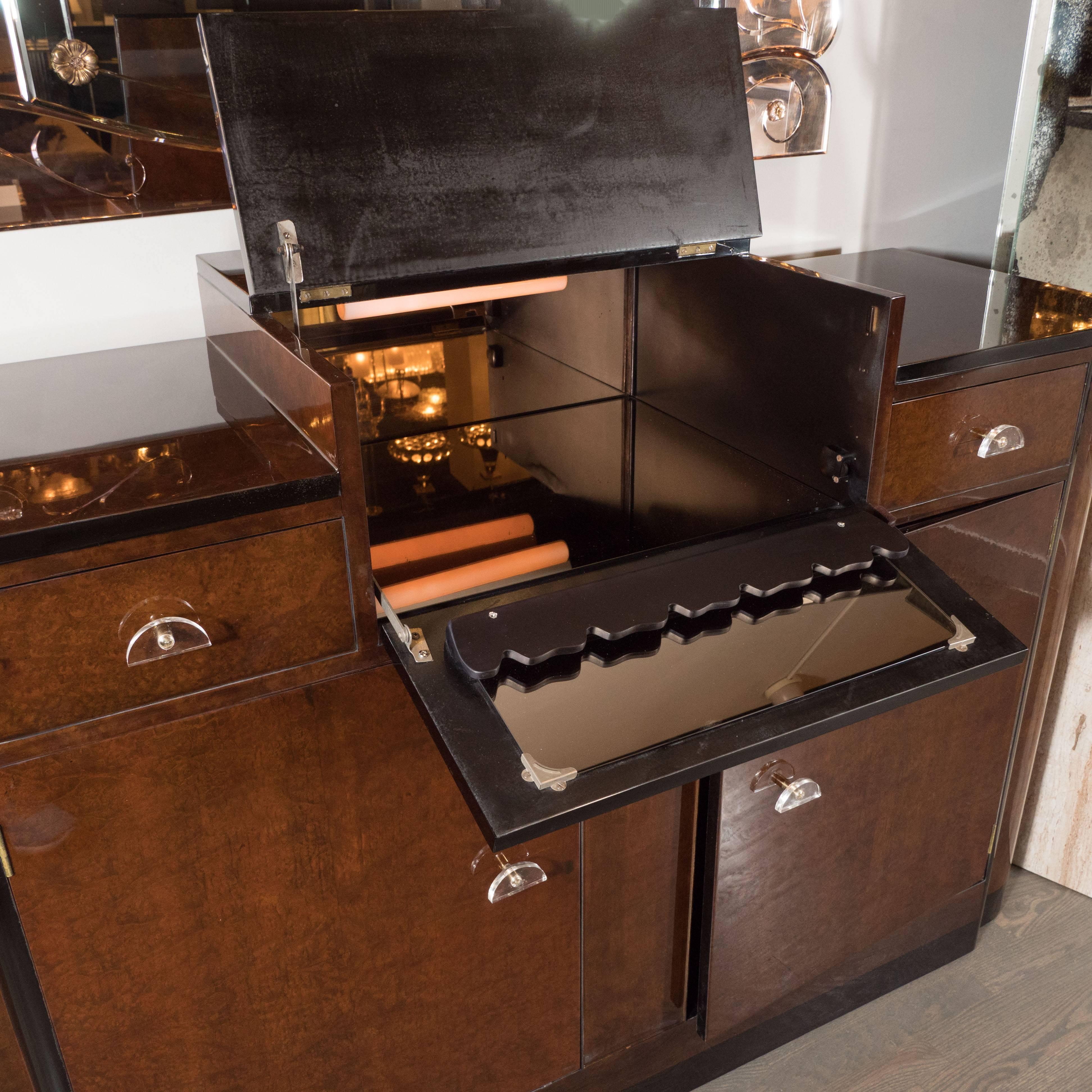 This stunning streamlined Art Deco Bar/ Cabinet was realized circa 1930 at the height of Art Deco. It embodies the aesthetic and materials that true collectors of American Deco cherish. Its skyscraper style body was created from book-matched burled