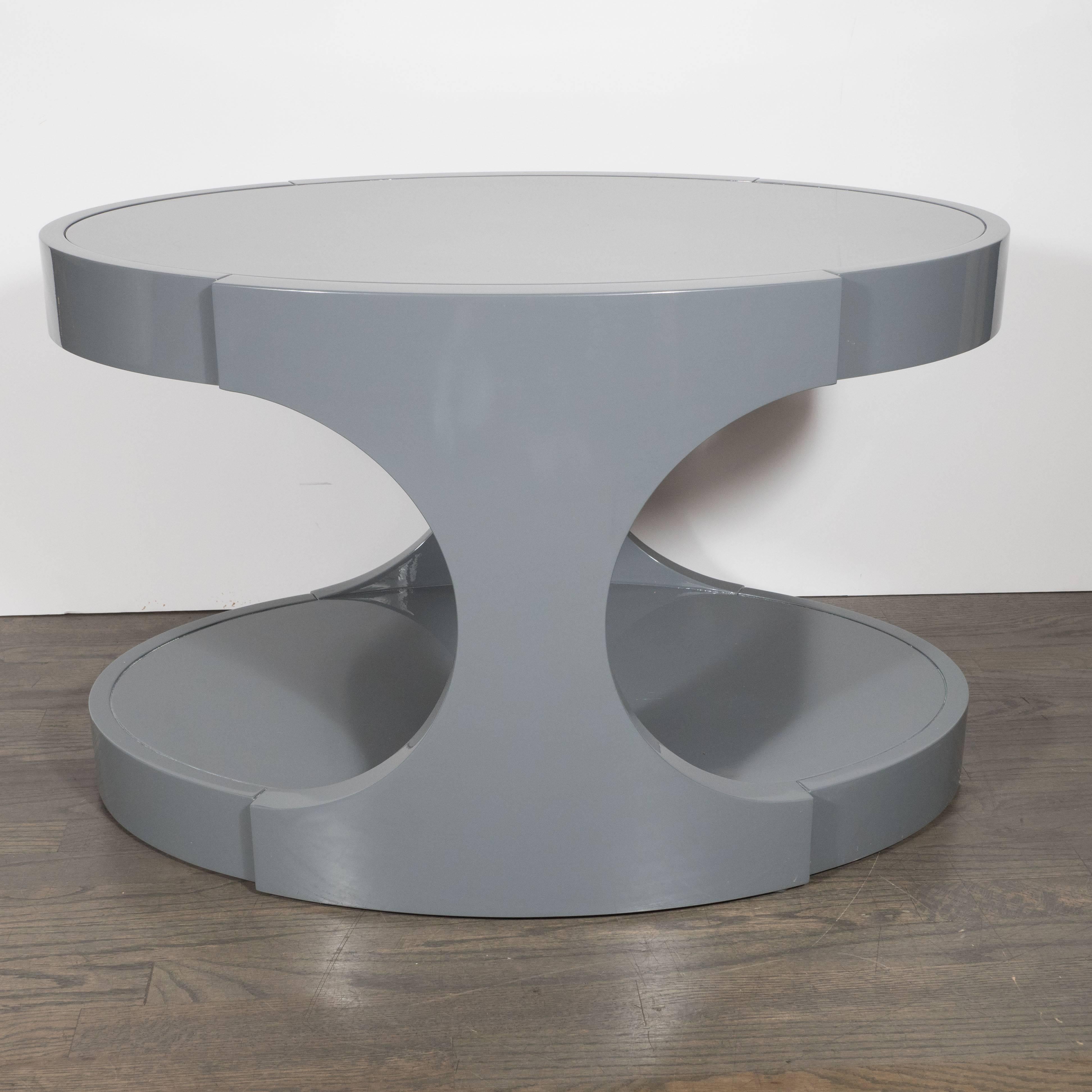 This fine pair of modernist side tables features two ovoid shaped tops connected with abstracted hour glass shaped side supports. These tables are a study in subtlety and understated excellence, with their perfectly smooth surfaces and seamless