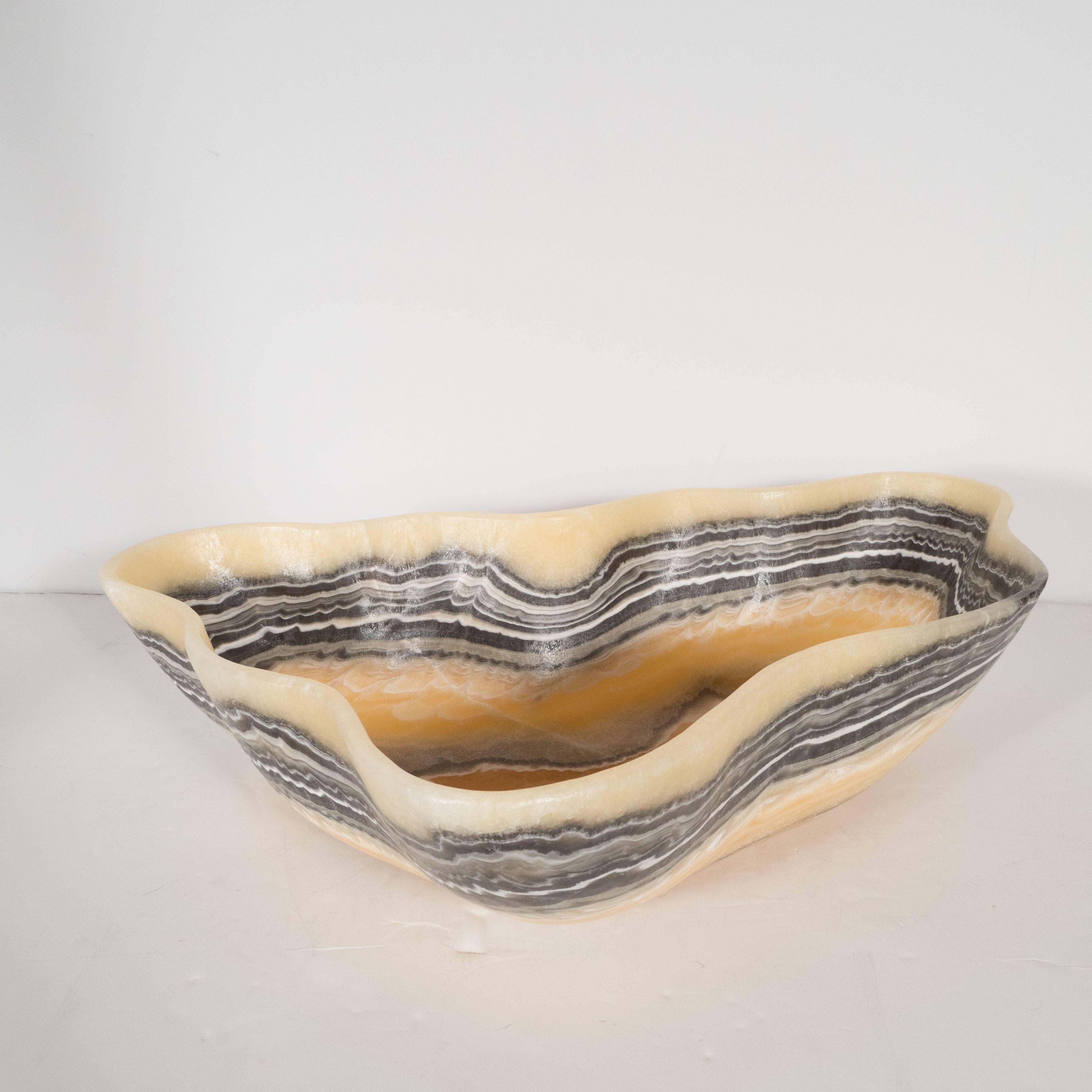 This compelling organic modern agate bowl features a wealth of texture in grisaille tones of charcoal, cream, and white set against a honey background, which adds a touch of warmth to the otherwise monochromatic palette. This piece showcases the