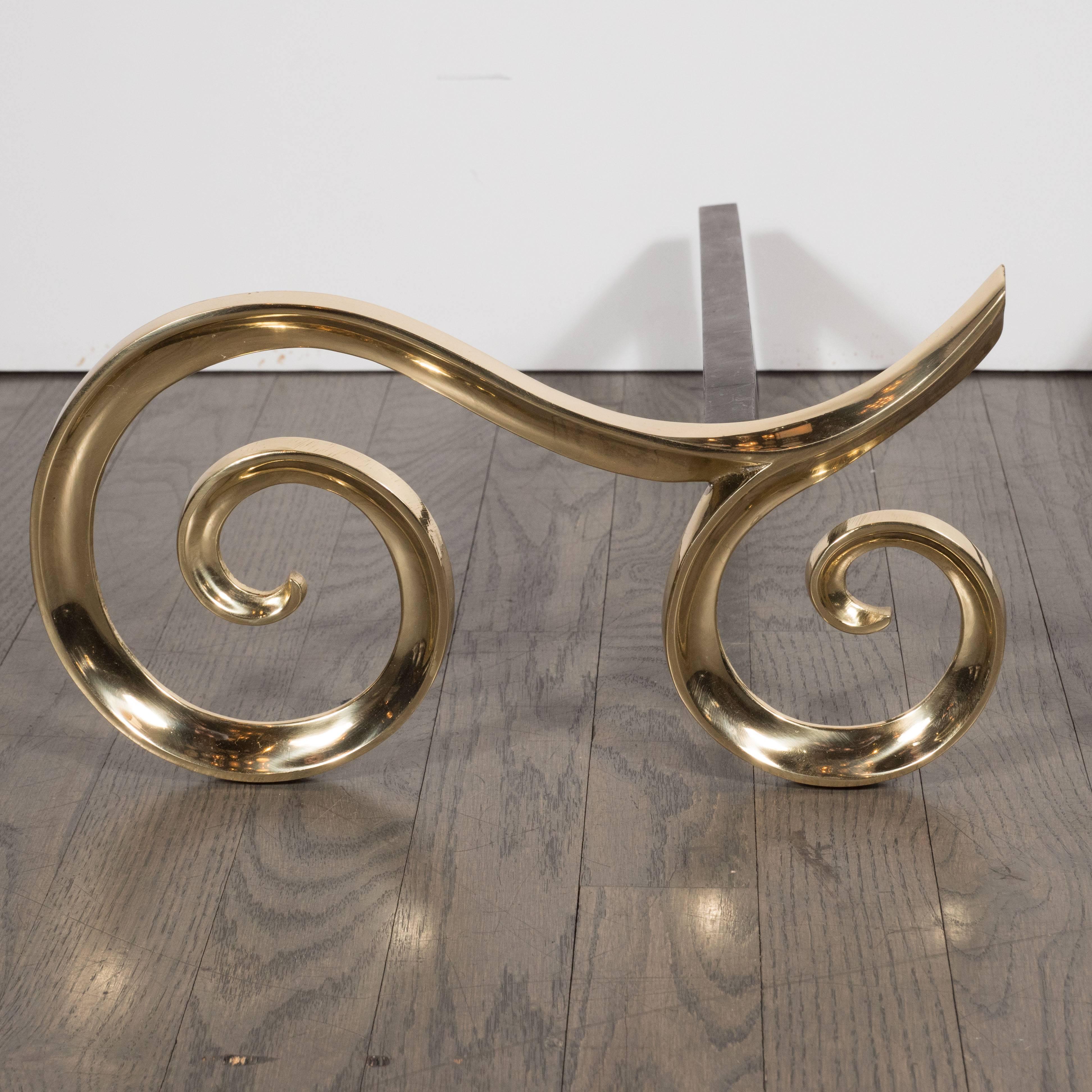 These elegant andirons feature scroll form fronts in lustrous brass and geometrically formed brackets in black iron. With their clean lines, classically inspired form, and luxurious materials, these andirons would be a wonderful addition to any
