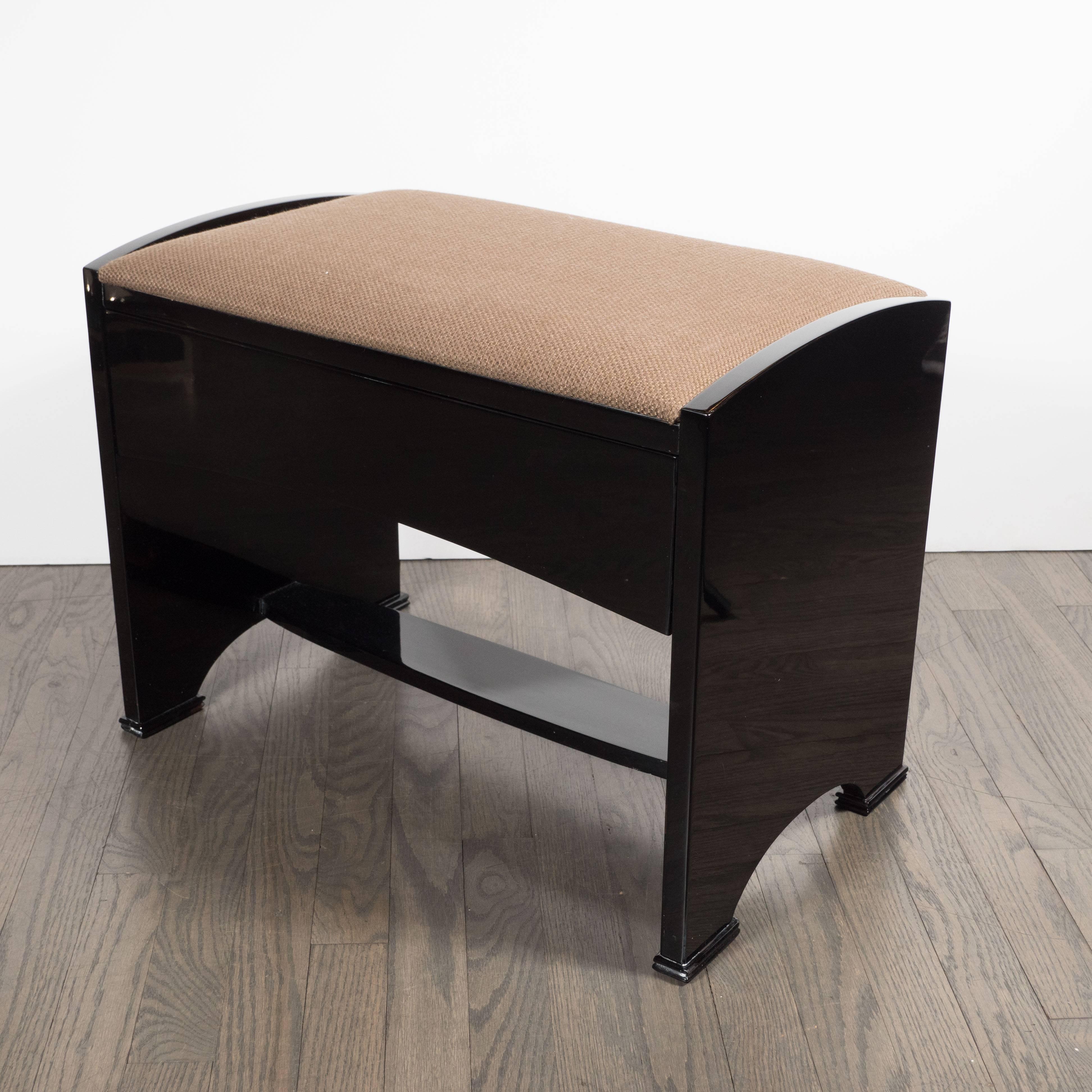 This refined streamlined Art Deco bench was realized in the United States, circa 1935. It features two lustrous black lacquer sides with subtly bowed tops and bottoms, as well as rectangular feet. It also offers a spacious drawer, perfect for