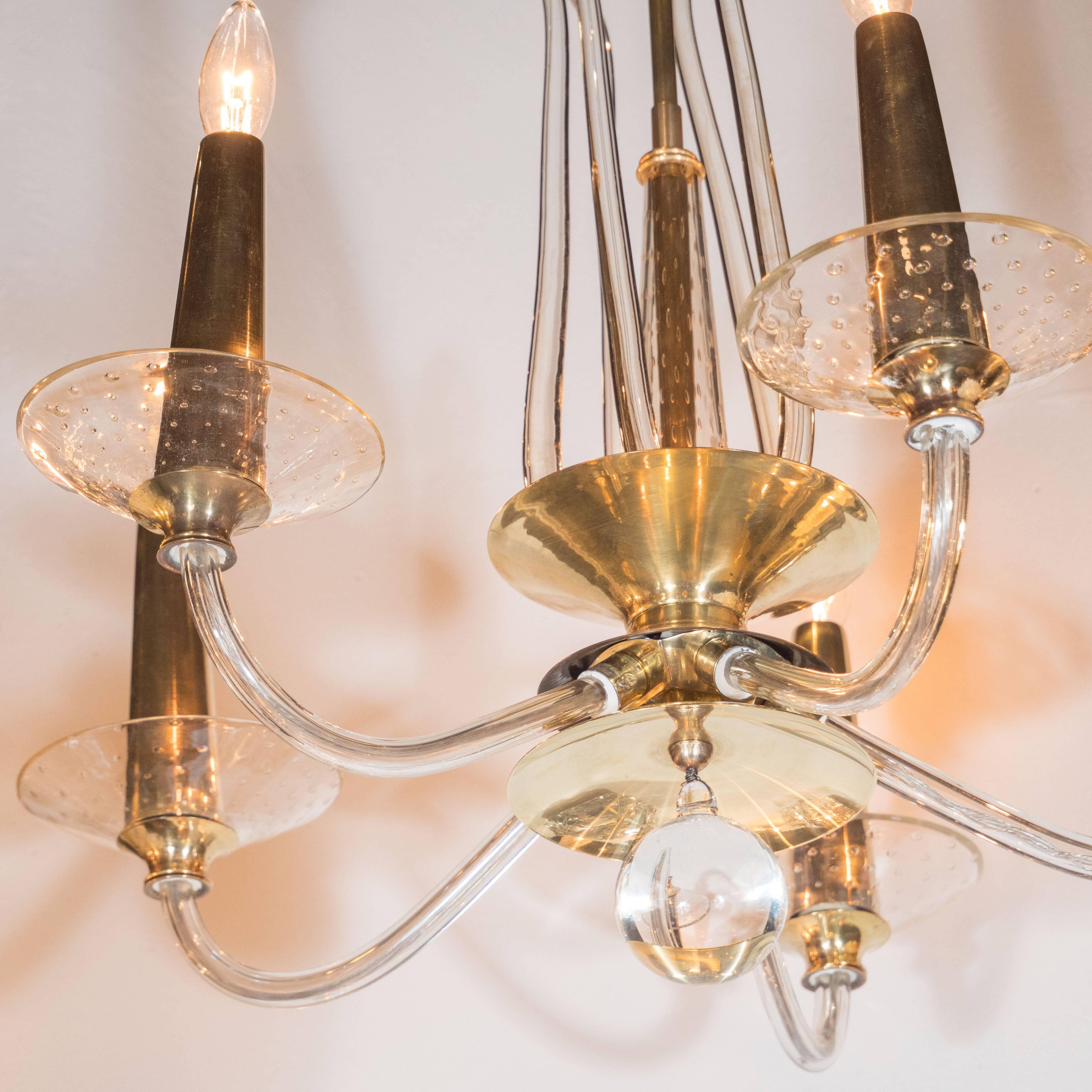 This stunning four-arm chandelier was handblown in Murano, Italy, the islands off the coast of Venice renowned for centuries for their superlative glass production. It features four curved arms that culminate in conical brass supports atop bobeches