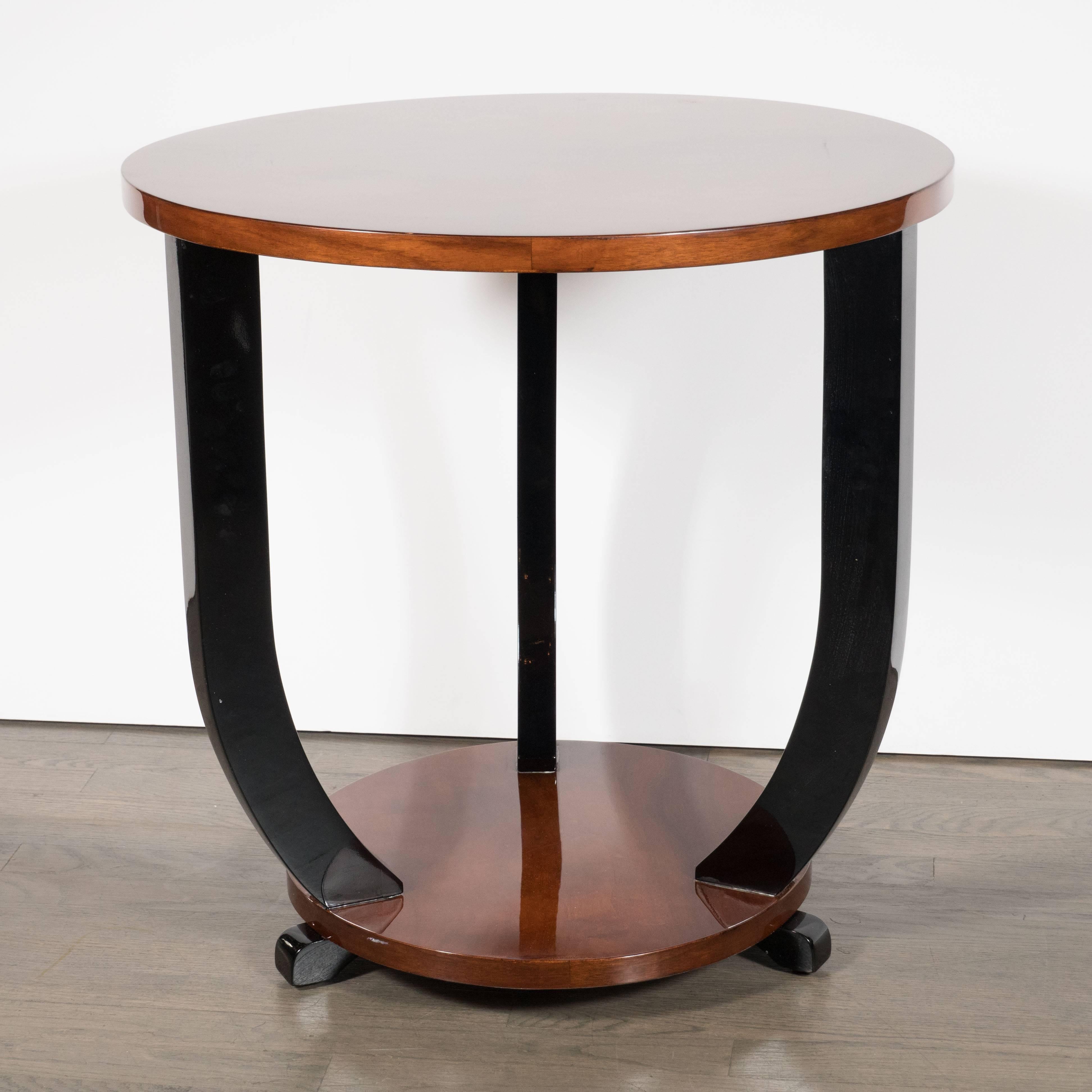 Cette étonnante table de guéridon Art déco a été réalisée en France, vers 1935. Il se compose de deux plateaux ronds en noyer assortis reliés par des supports courbes en laque noire. Les pieds en forme de volute, exécutés en laque noire, s'élèvent