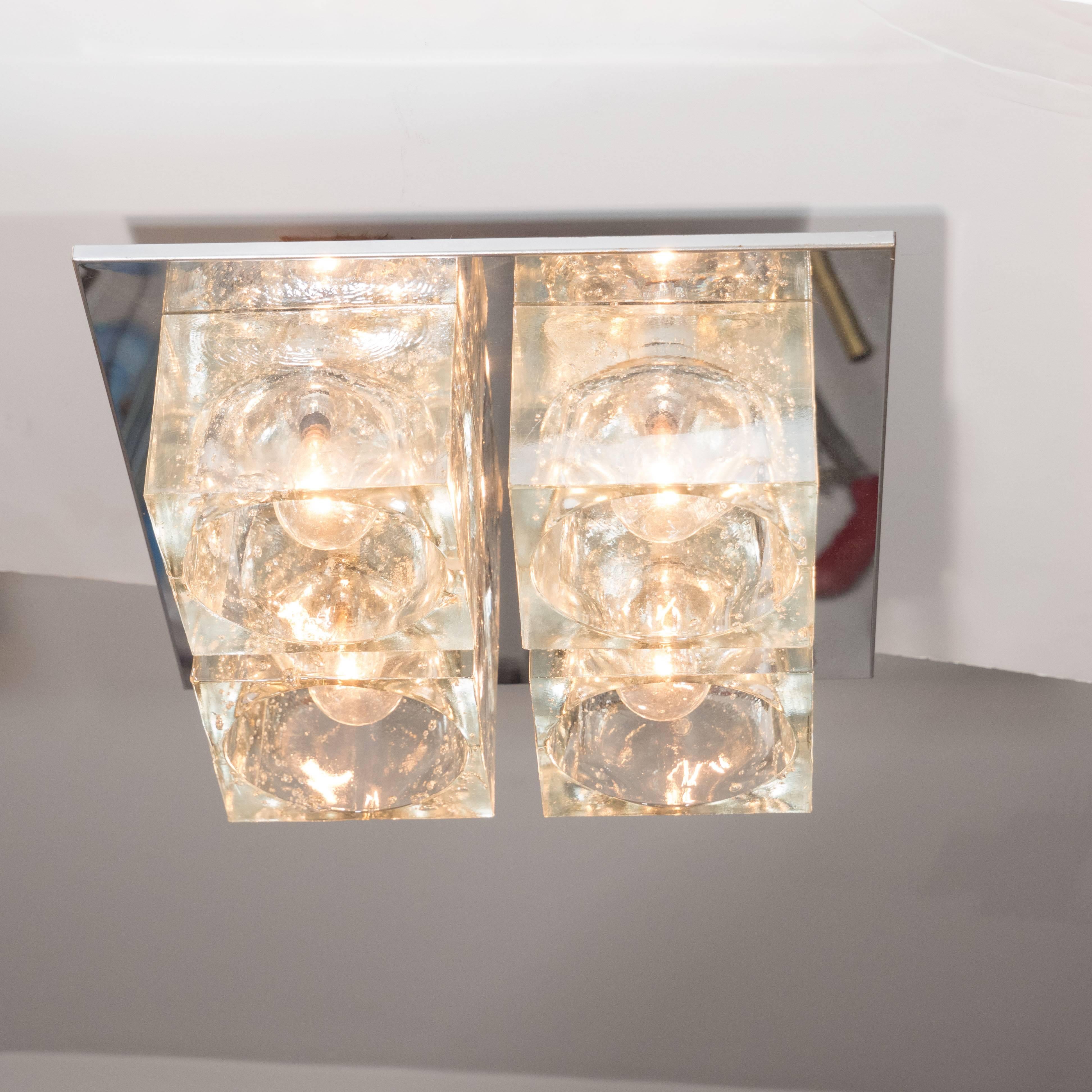 This brilliant Mid-Century Modern flush mount chandelier was realized by the esteemed Italian glass studio Sciolari, circa 1970. It features four thick translucent glass cubed shades with inset bulbs attached to a close fitting chrome backplate.