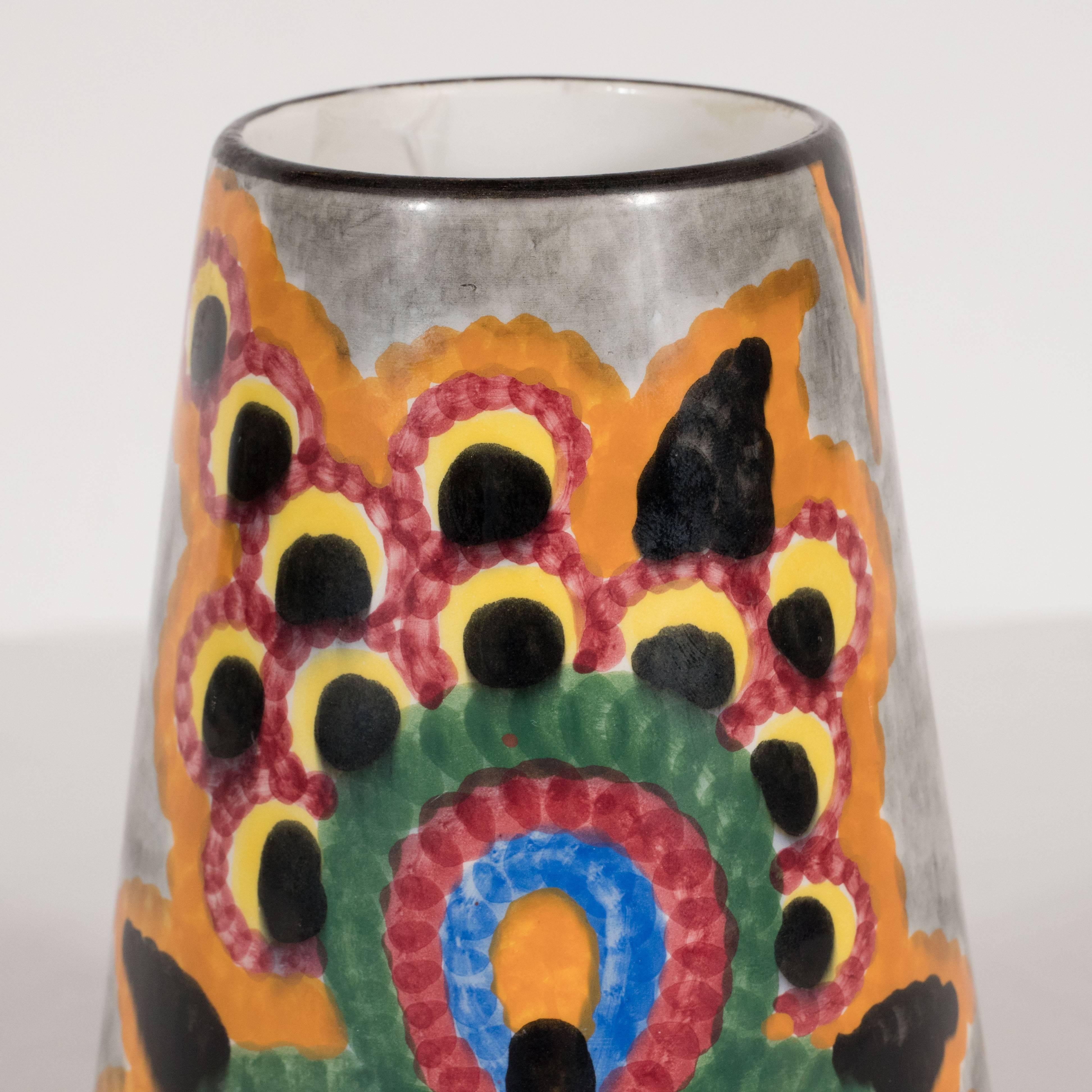 This gorgeous vase was realized by Schramberg SMF- one of Germany's most esteemed pottery studios since 1820. It has been meticulously handpainted in tones of pumpkin, pomegranate, mint, sky blue and sunshine yellow with black and smoke gray