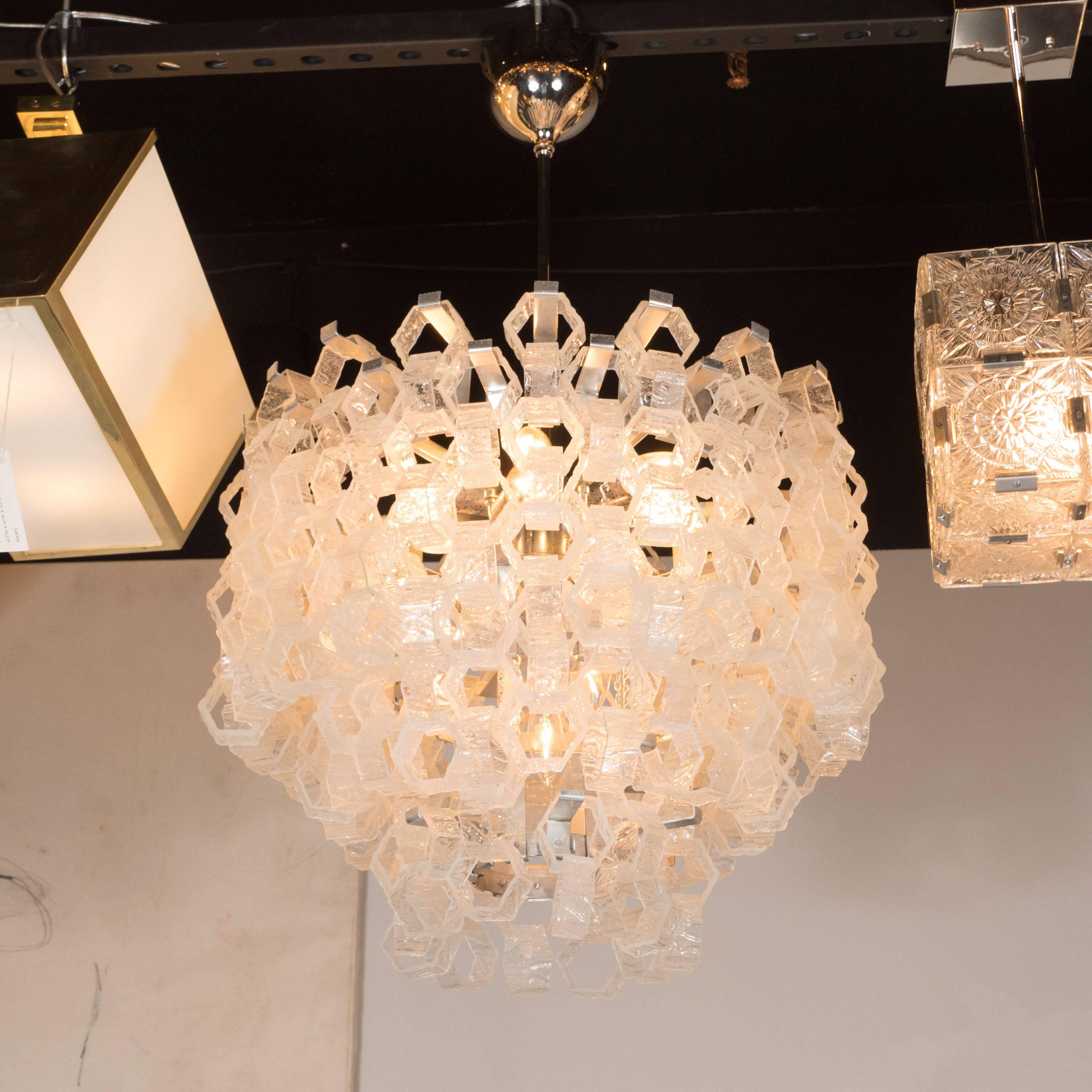 This sophisticated chandelier was produced by the storied glass blowing atelier, Mazzega in Murano, Italy, circa 1970. It features an abundance of hexagonal 