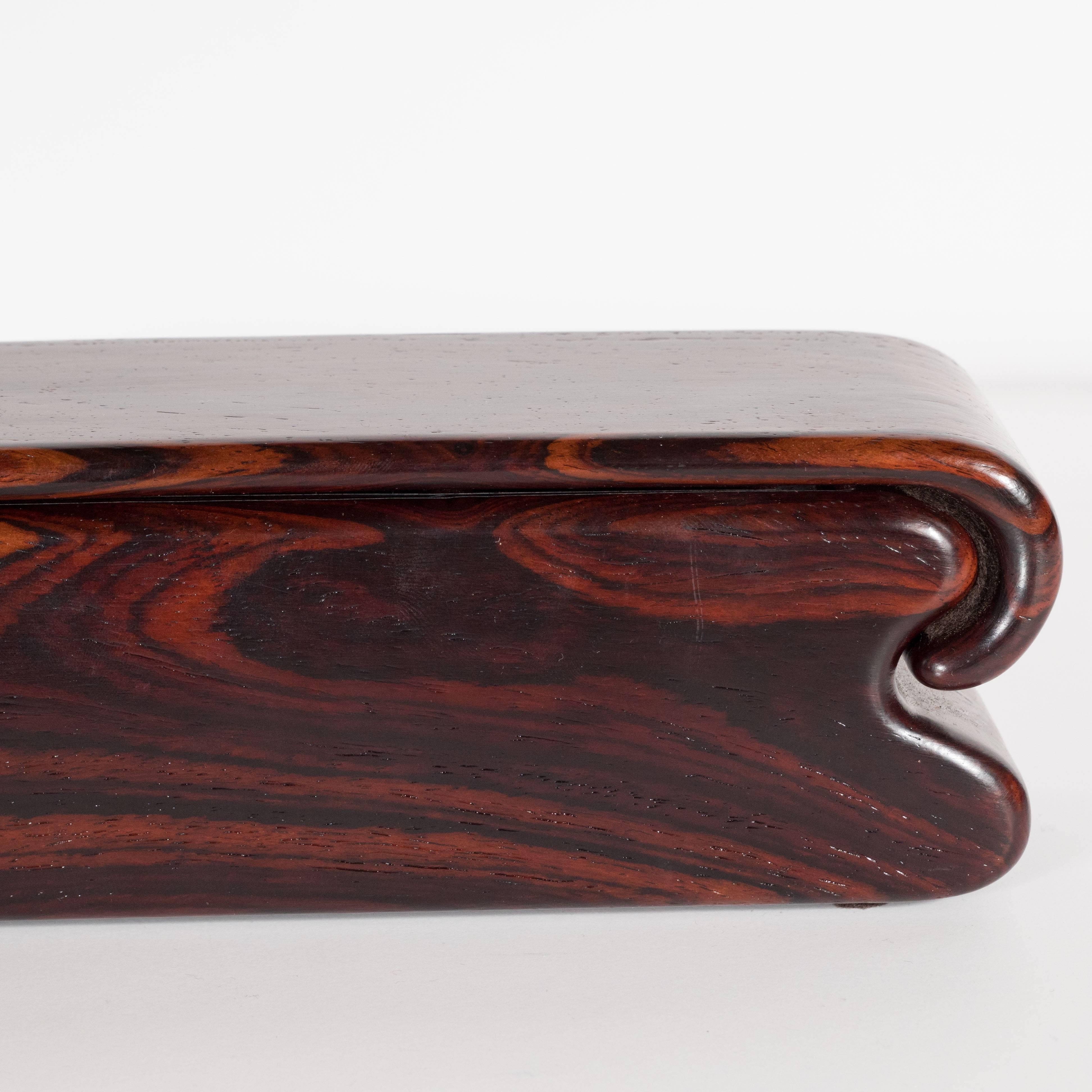 This stunning rosewood box was handcrafted by the contemporary artisan Nick Molignano, who developed his skills through working closely with master craftsman in Brazil. This piece offers a rounded notched end with a curved top that slides in to the