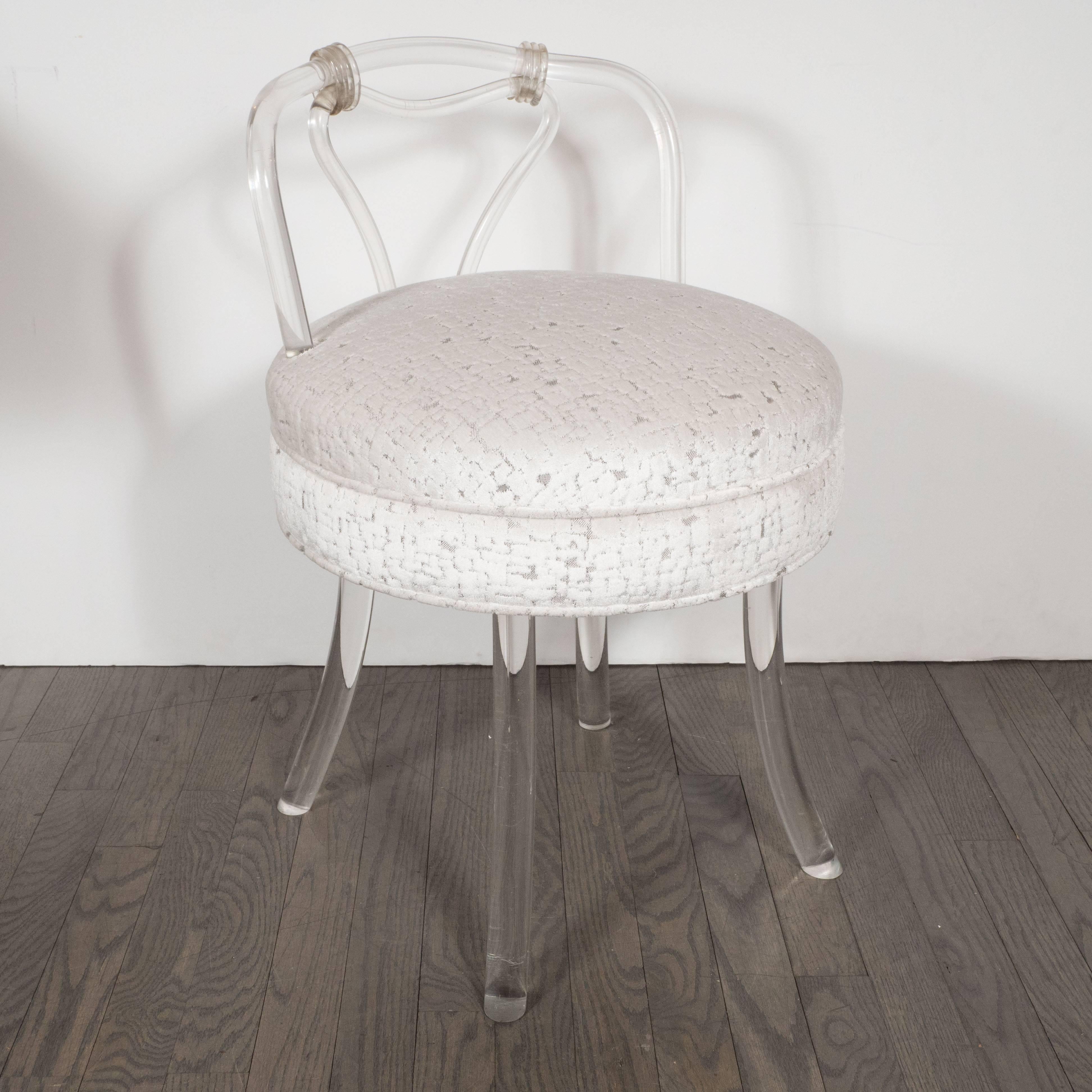 This sophisticated and glamorous Lucite stool was realized in America, circa 1950. Produced in the Hollywood regency style, this piece recalls the refined sensibility of a bygone era. It features an undulating back composed of Lucite with an