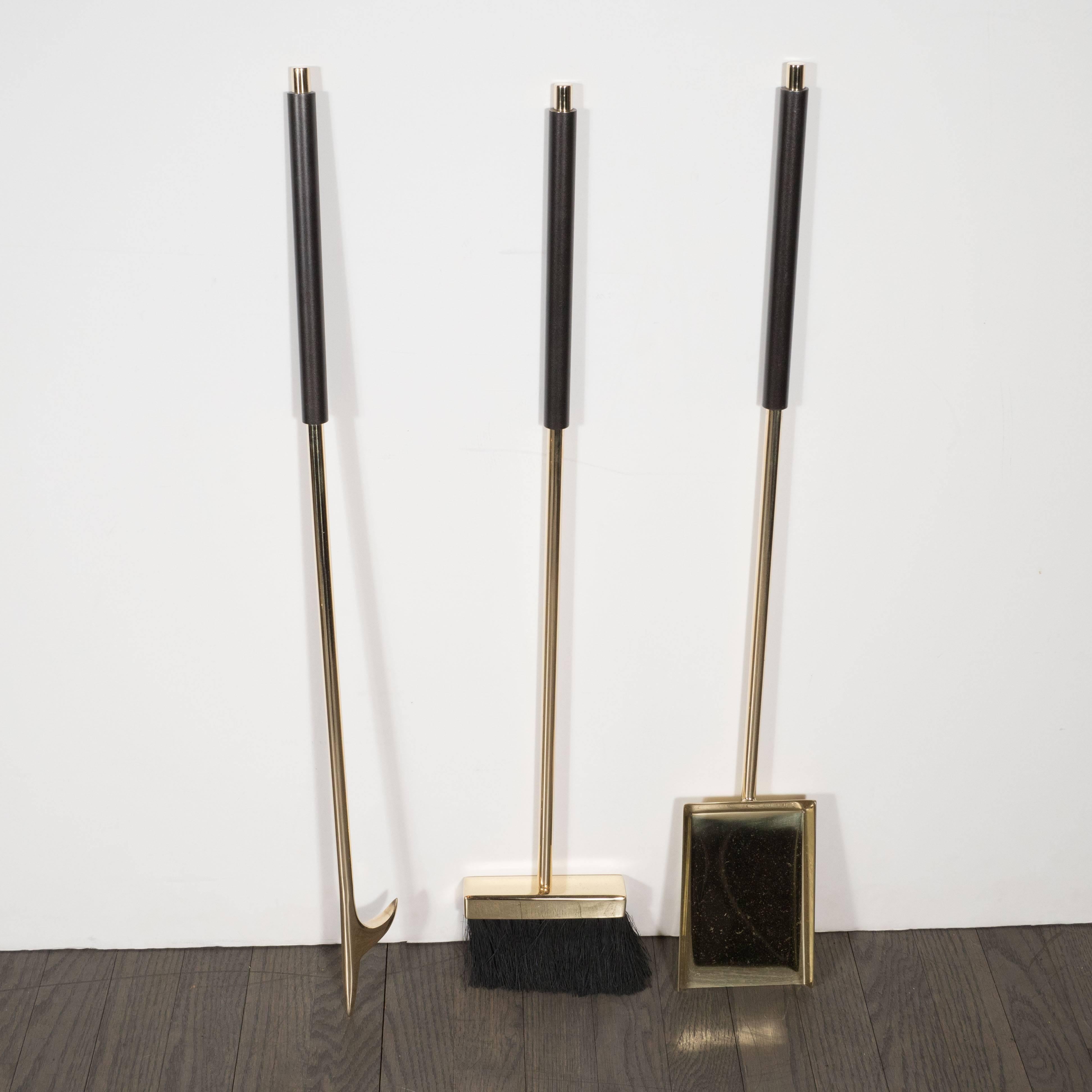 This refined and luxurious custom fireplace tool set includes stand, shovel, brush, poker and tongs realized in lustrous polished brass. The fire tool pieces offer oil rubbed bronze handles with lustrous brass ends. This is not only an incredibly