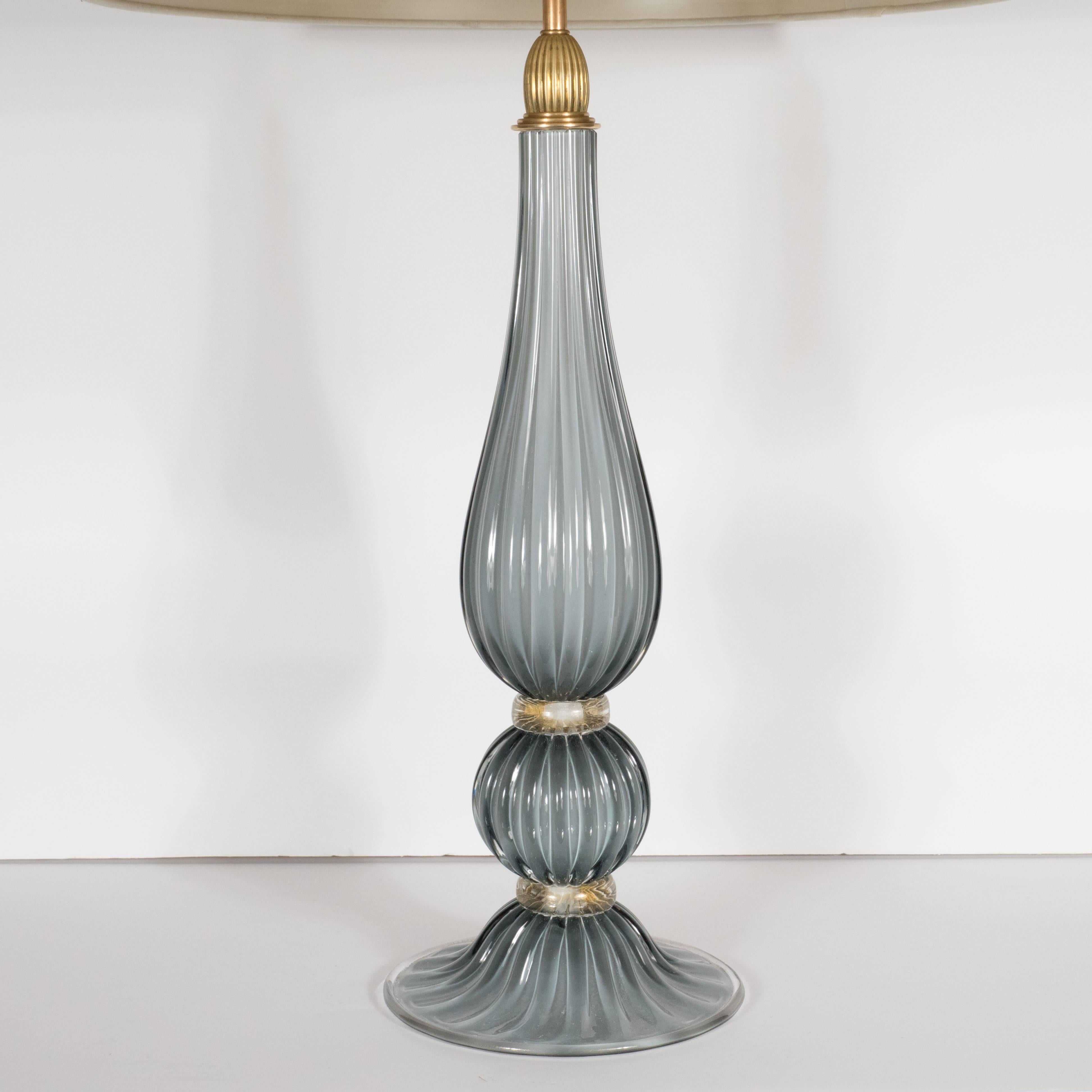 This refined pair of modernist table lamps were handblown in Murano, Italy- the islands off the coast of Venice renowned for centuries for their superlative glass production. They feature undulating forms in a smokey dove gray with an orbital form