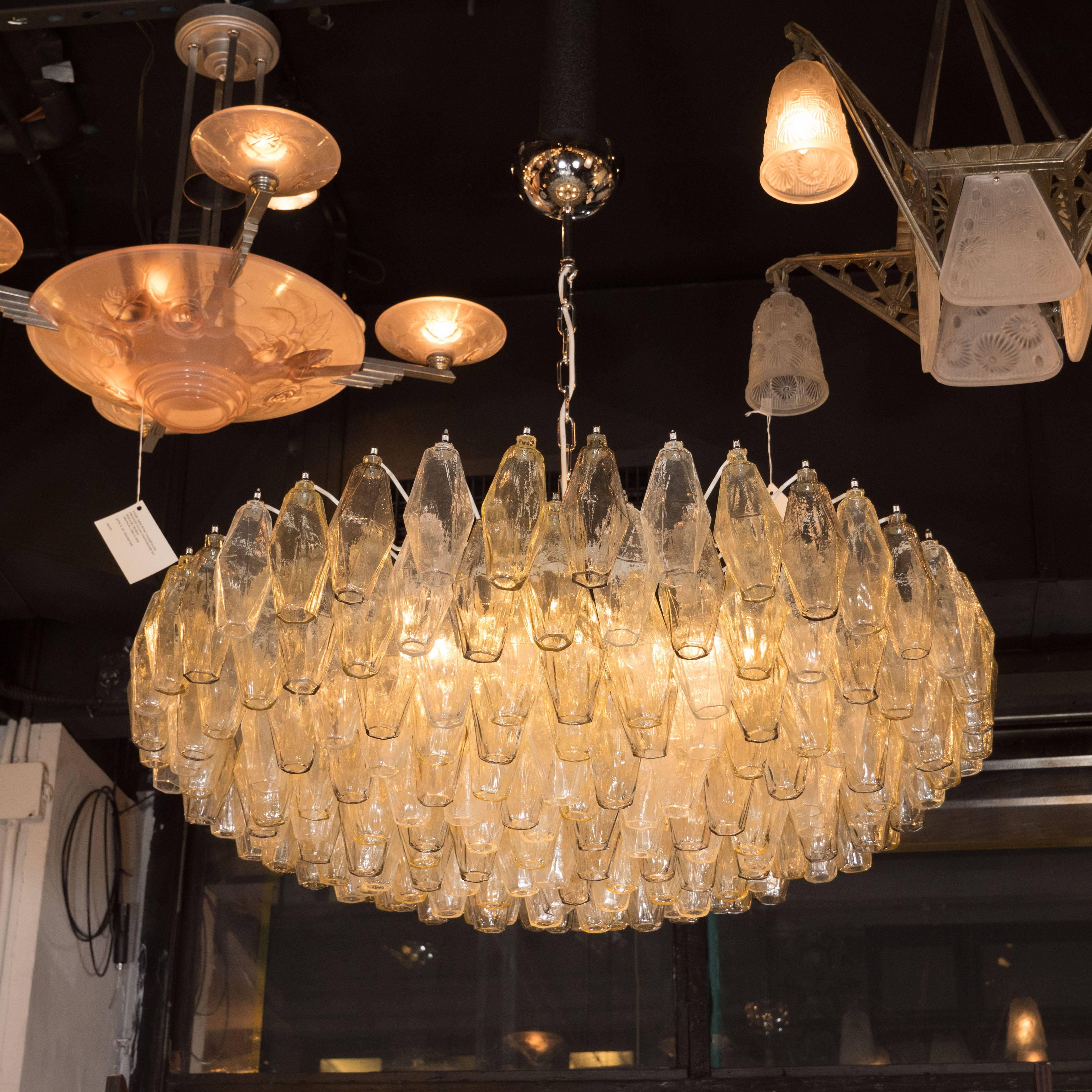 This elegant Murano glass chandelier, in the manner of Venini, features a constellation of handblown Murano glass polyhedral glass shades in a smoked topaz hue. The frame, fittings and canopy are composed of polished nickel. Each shade has been hand