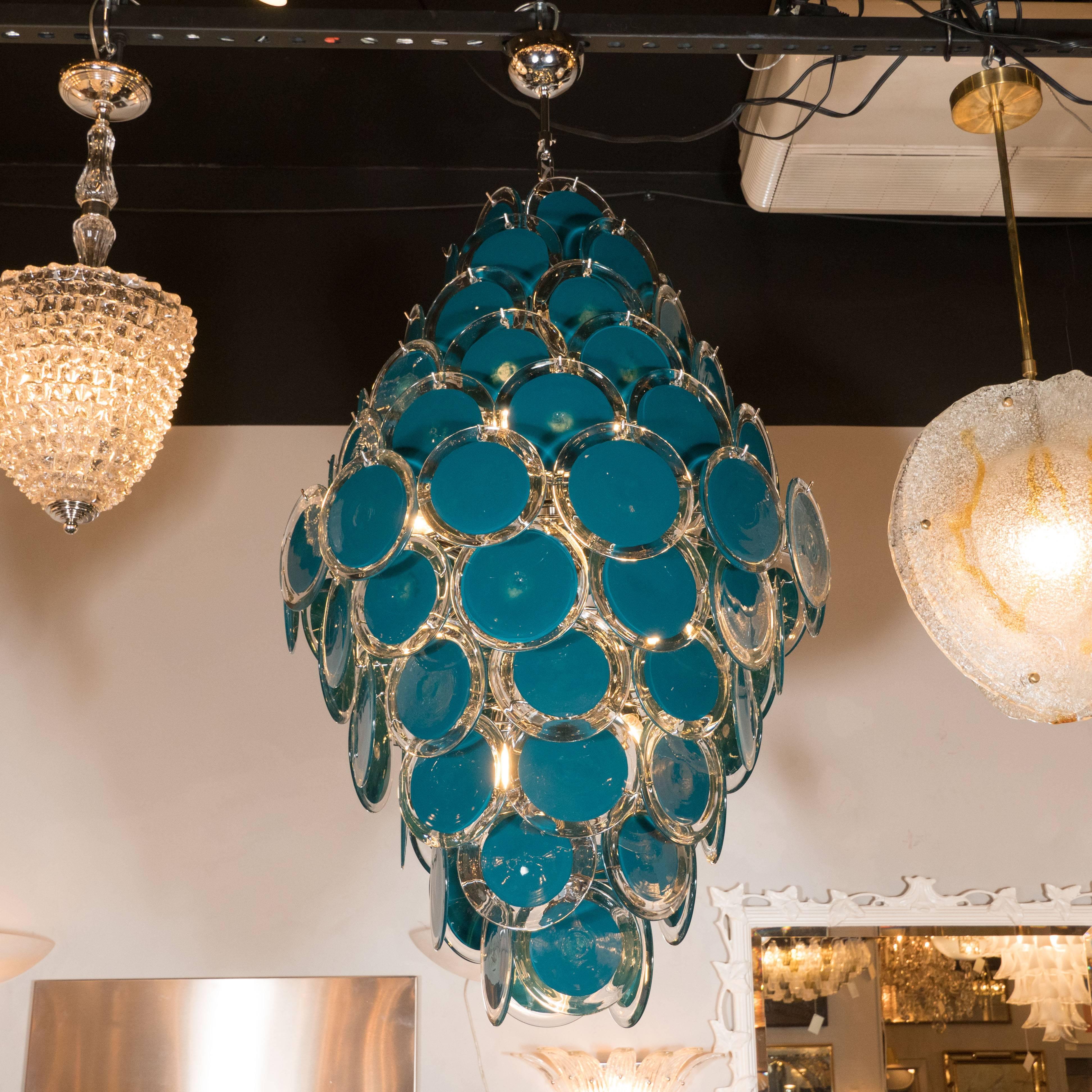 This stunning and bold chandelier was handblown in Murano, Italy- the islands off the coast of Venice renowned for centuries for their superlative glass production. It features ten tiers of cerulean blue discs with clear perimeters that taper at its