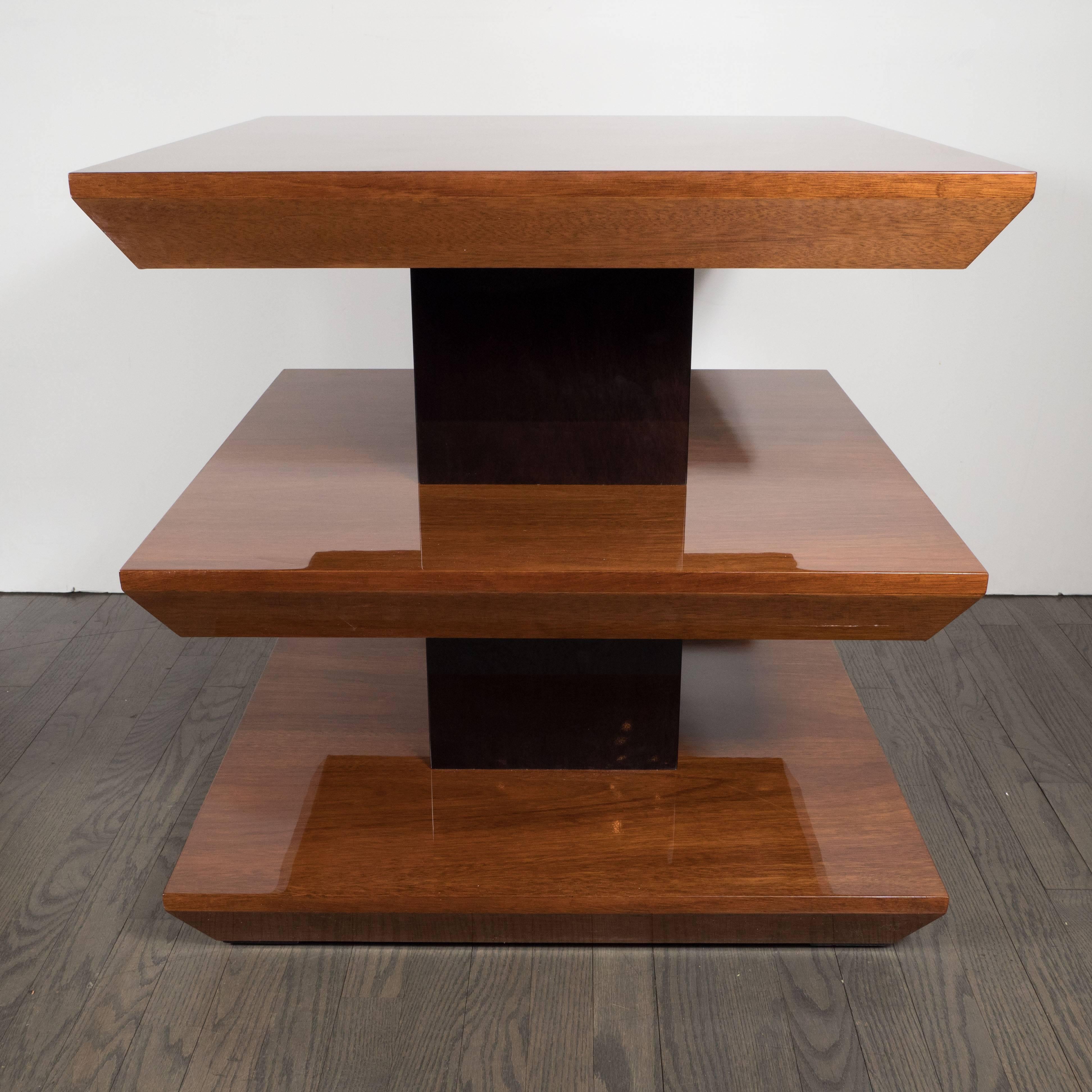 This elegant skyscraper style side table was realized in France, circa 1935, at the height of Art Deco. It features three square tiers that recede downwards at angle from their squared off perimeters suggesting inverse pyramidal forms. The tops have