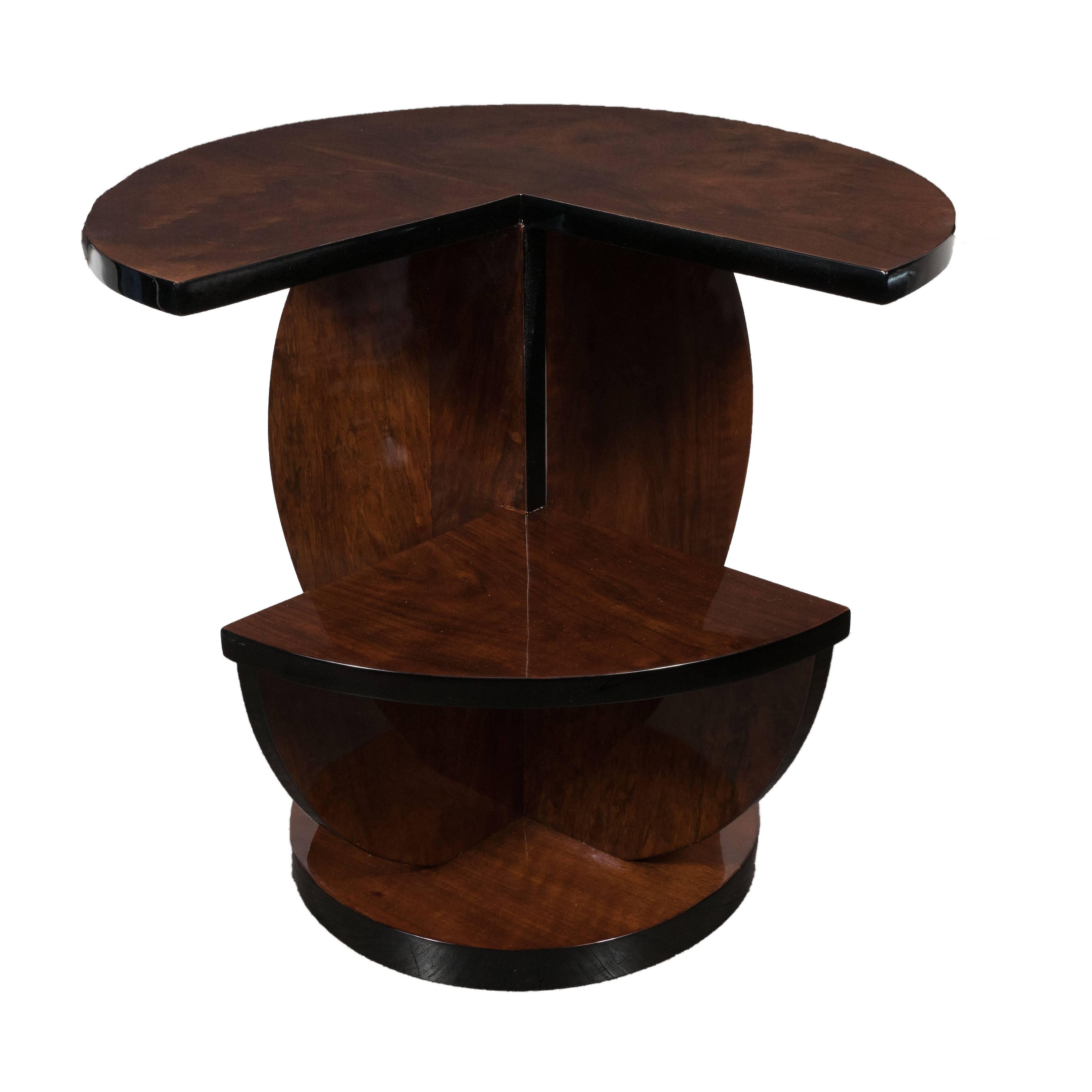 This elegant and graphic side table was realized in France, circa 1935, but appears as modern as ever. It offers two tiers composed of bookmatched burled walnut circumscribed with black lacquer around the curved edges of each form. The top tier