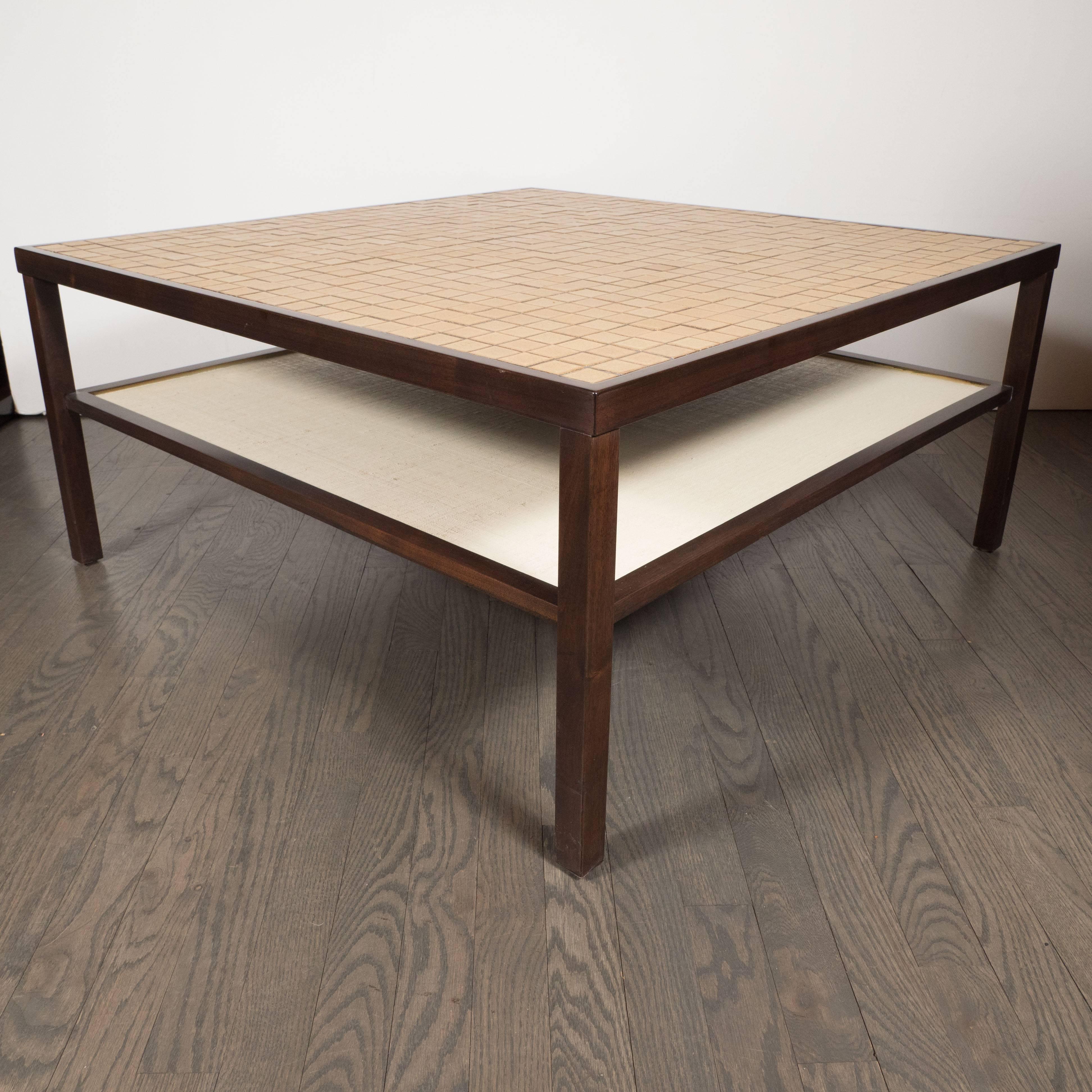 This sophisticated Mid-Century Modern two-tier cocktail table was realized by the esteemed pair of Mid Century Modern designers Jane and Gordon Martz in the United States, circa 1960. It features a hand rubbed walnut frame; a top consisting of a