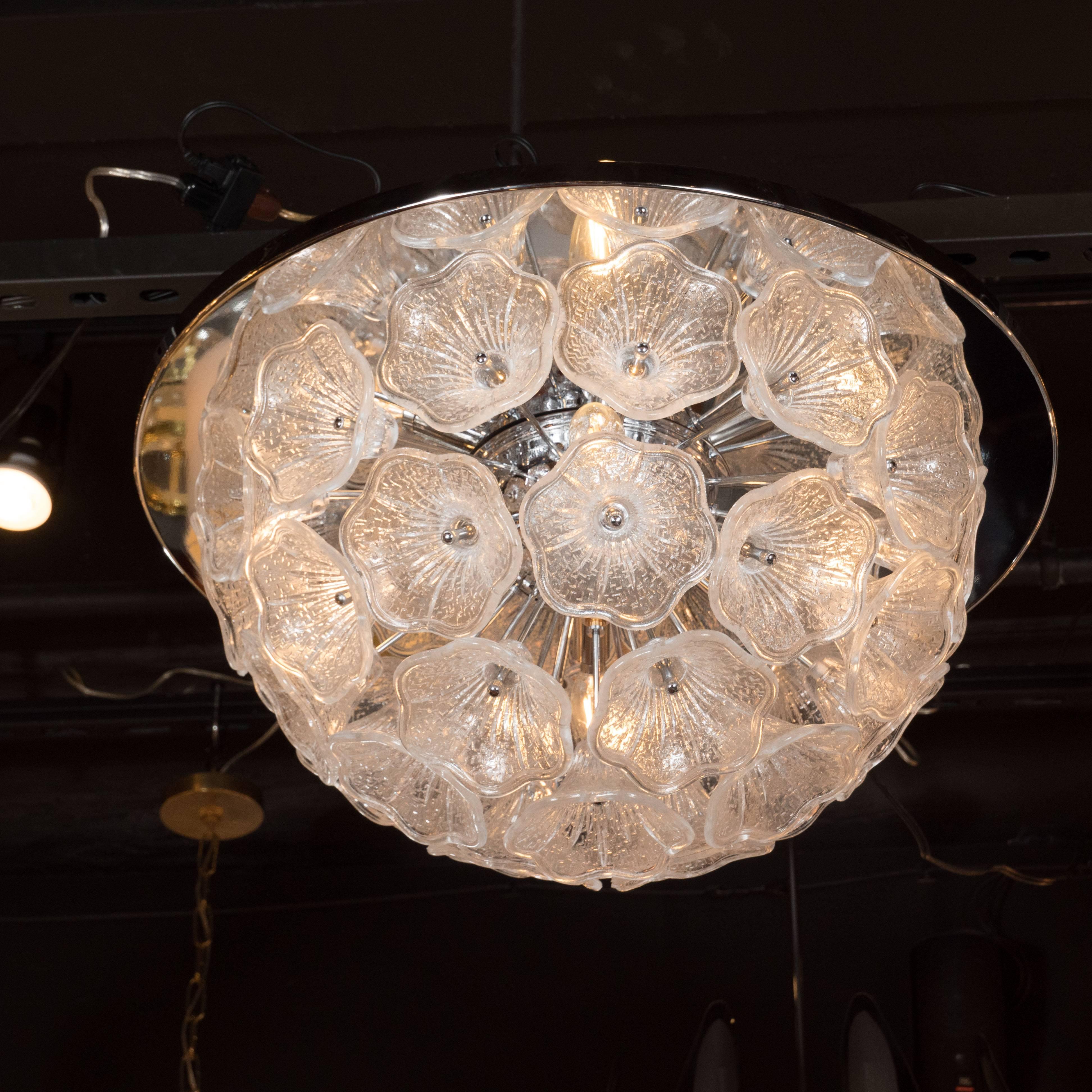 This luminous flush mount Sputnik chandelier features an explosion of hand blown Murano glass flower petals connected to a central polished chrome orb with chrome arms. The floral saucers are inscribed with a subtle geometric pattern and illuminated