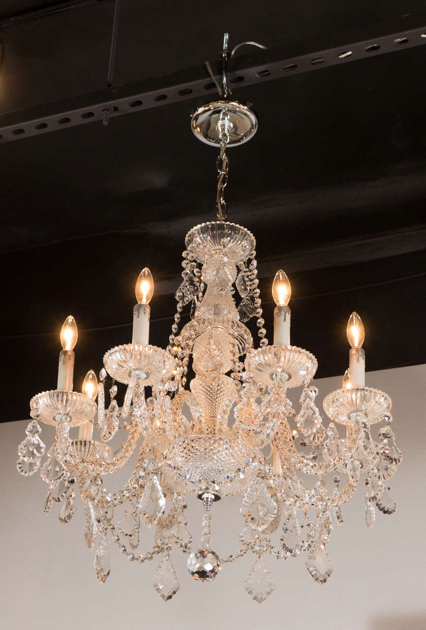 This fine cut crystal chandelier features an eight-arm design was realized in the United States, circa 1950. It features Fine cut crystal pendants draped with prismatic crystal embellishments. The cut crystal bobeches feature Fine ribbed and fluted