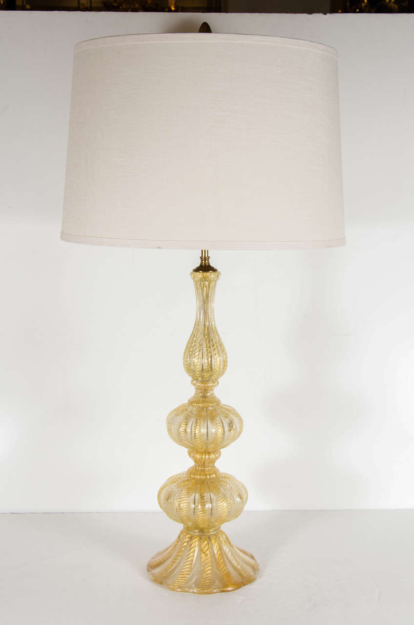 This elegant Mid-Century Modern table lamp was hand-blown in Murano, Italy by the esteemed studio Barovier e Toso, circa 1950. It offers a reeded undulating form consisting of stacked ovoid forms- separated by fluted hourglass shaped embellishments-