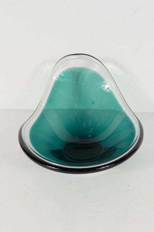 This hand blown murano glass bowl features a wave design in emerald green with a smoked clear surround . A really great amorphic design.