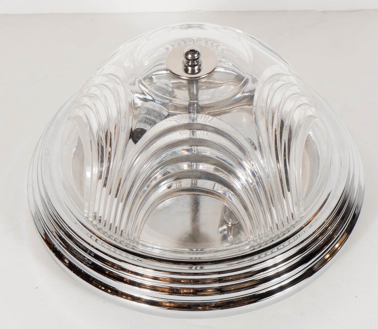 Art Deco style flush mount chandelier with chrome fittings. This Art Deco style flush mount chandelier features a rounded chrome canopy with a multi-tiered stepped Skyscraper style designed outer trim that holds its hand-cut crystal dome that