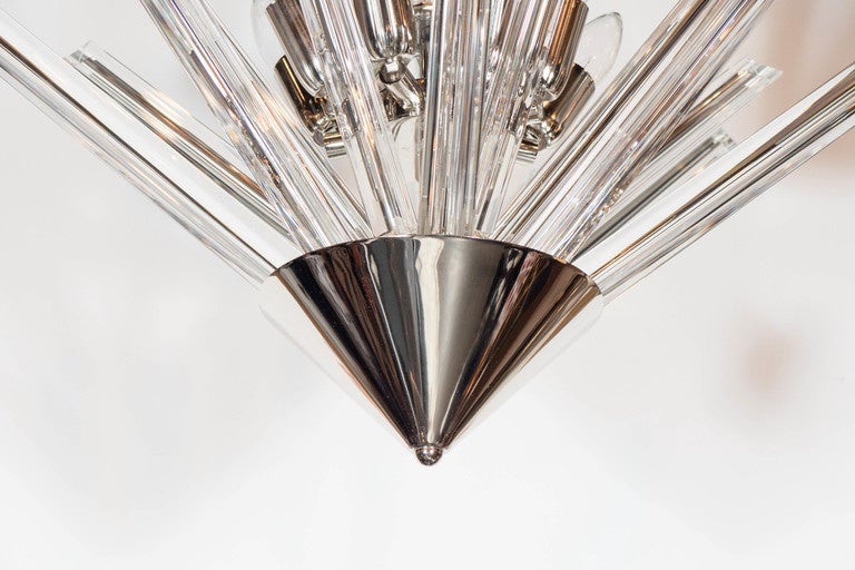 This stunning Mid-Century Modern chandelier is hand blown in Murano, Italy- the island off the coast of Venice renowned for centuries for its superlative glass production. It features three-tiers of triedre crystals chandelier that emanate outwards,