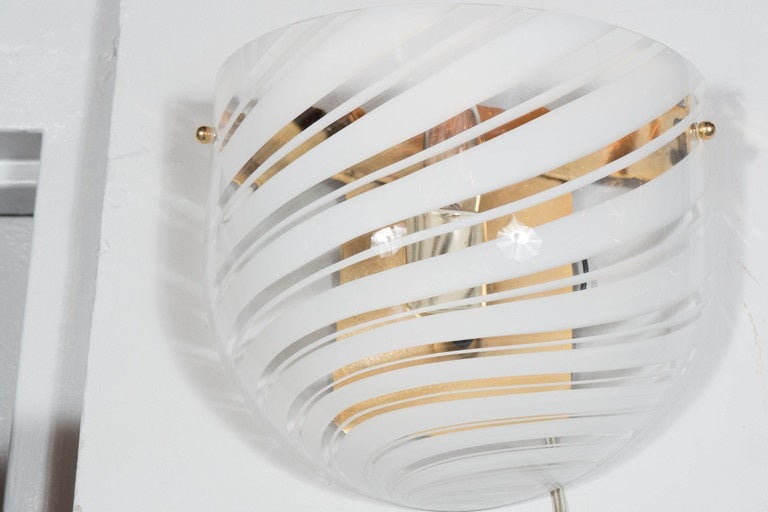 This gorgeous Mid-Century Modernist wall sconce features a rounded Murano Glass shade with a white swirl design which covers the brass fitting. With its simple elegant form, this fixture is incredibly versatile- blending seamlessly with virtually