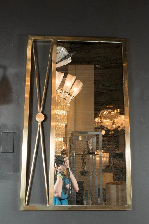 This stunning mirror features an x form design with a frame detail all in solid brass. This is a extremely well made mirror with great style and design.