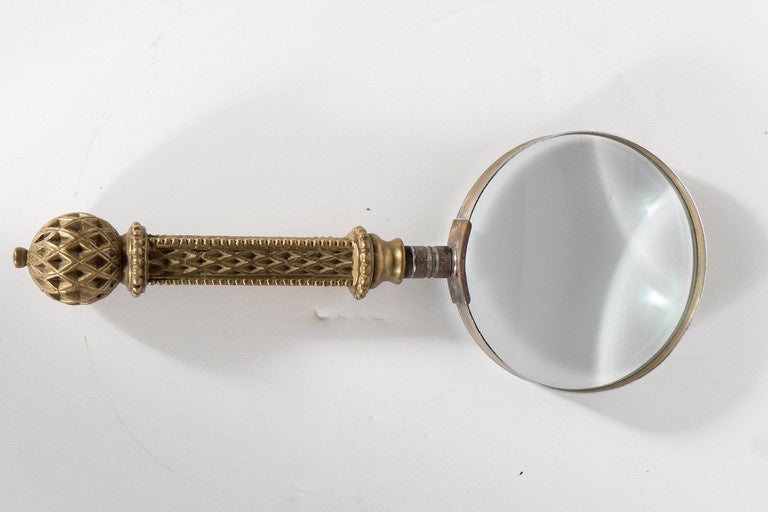 This very elegant magnifying glass features a gilt handle with a Moroccan style motif very exemplary of the late Victorian and Edwardian period. This would make a great desk accessory.