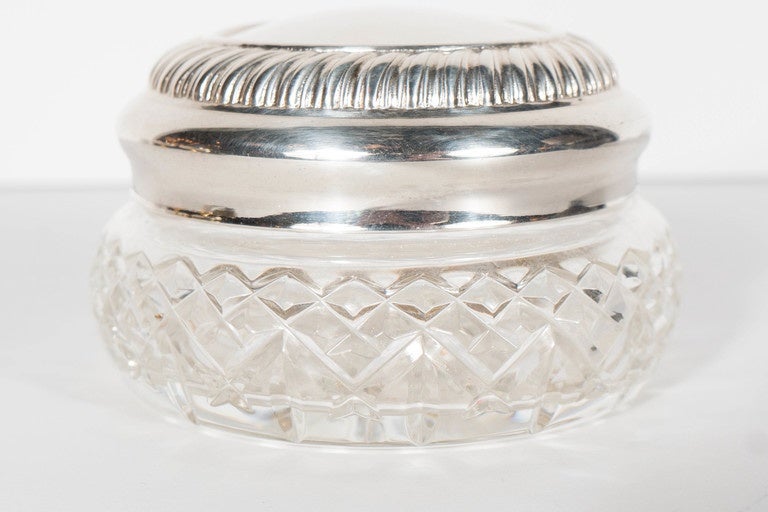 This very elegant box features a silver plate top with a ribbed detail and a cut crystal circular box with cross hatched detailing. This is in excellent condition. Would be great as a jewelry box or accessory on a vanity or bathroom.