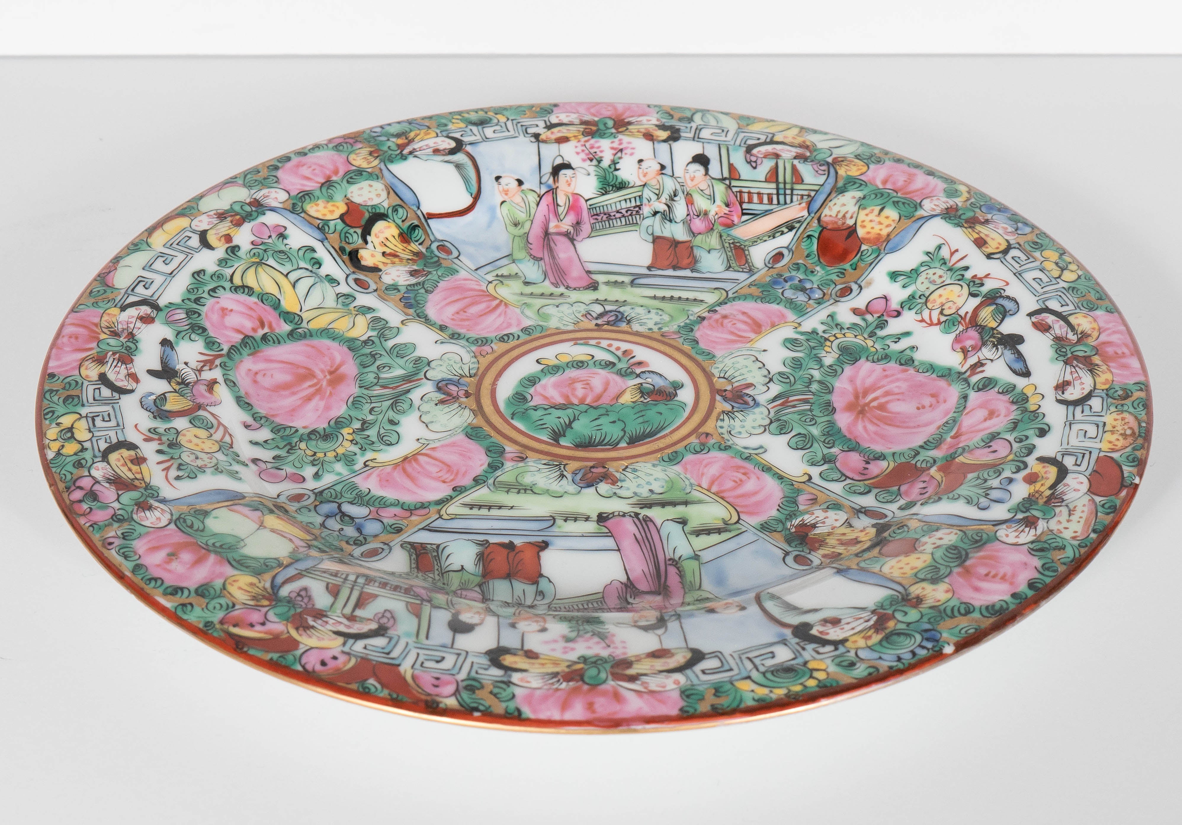  Chinese rose medallion or rose famile porcelain hot water plate. Two images of daily life and two images of birds and flowers adorn the plate with a gilt rim. Floral decoration on the outside of the footed plate on a white background. A gorgeous